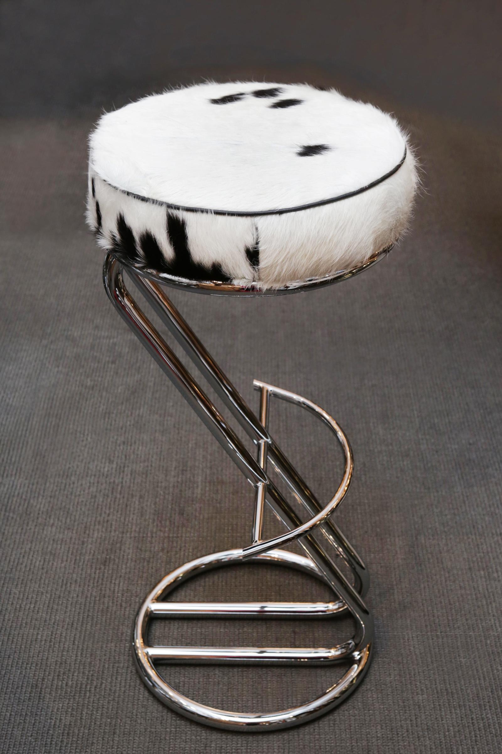 Bar stool pony A upholstered and covered with natural 
pony on polished stainless steel base. With footrest.