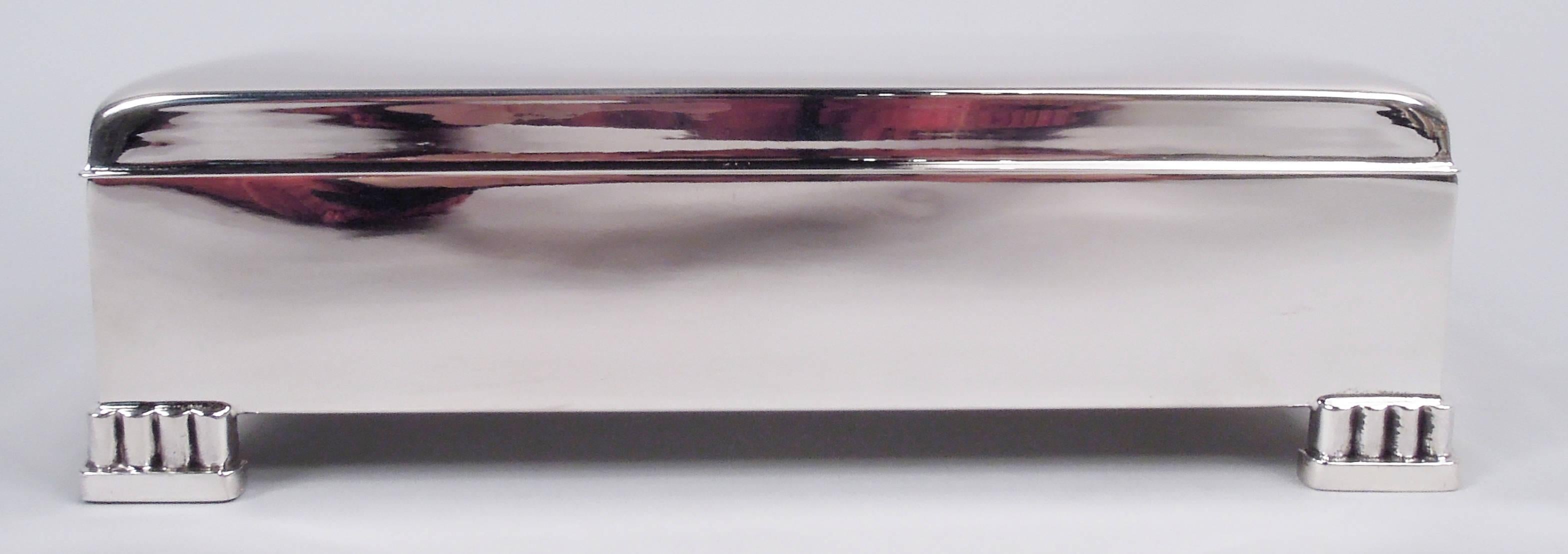 Classic Midcentury Modern sterling silver box. Made by Poole in Taunton, Mass. Rectangular with straight sides. Cover hinged with curved top, straight sides, and flat overhanging rim. Corner bracket colonnade supports on low mount. Interior velvet
