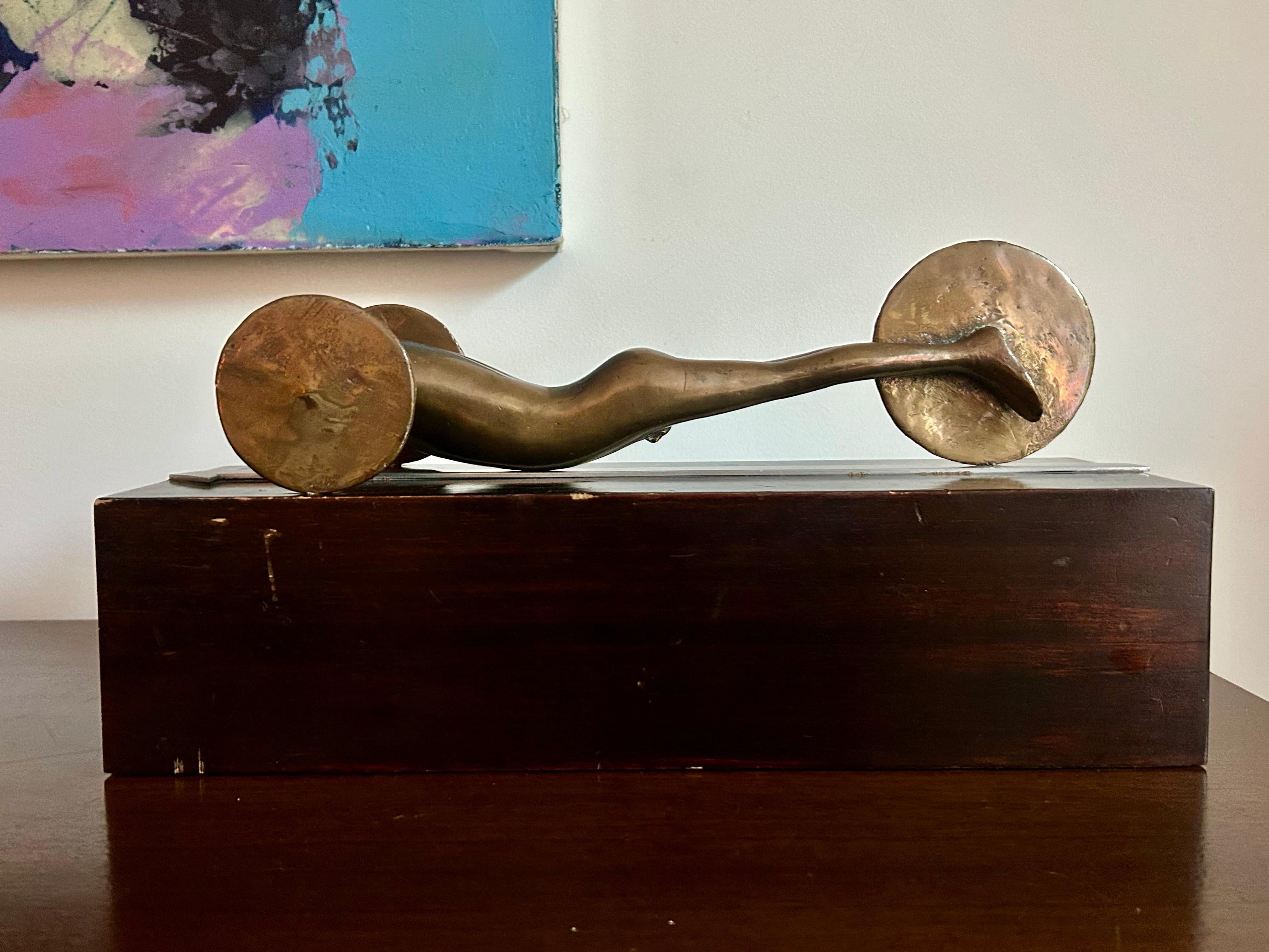 Original artwork.
Unique piece.
Solid cast bronze form on solid enameled wood base with aluminum arrow detail.
Original vintage condition showing minor wear consistent with age and use, patina on the bronze and missing needle on the back wheel that