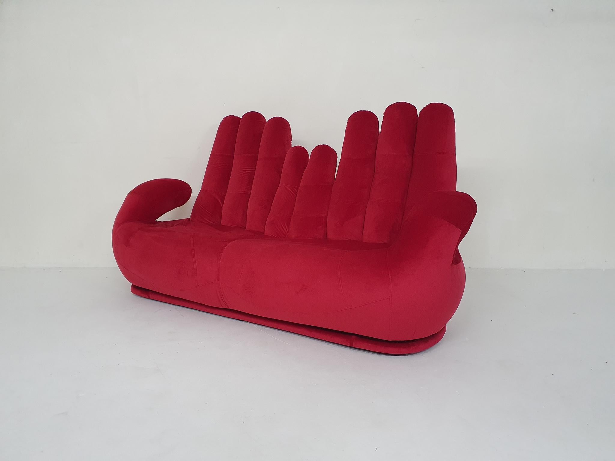 Vintage sofa shaped as two hands, re-upholstered in red velvet.

 