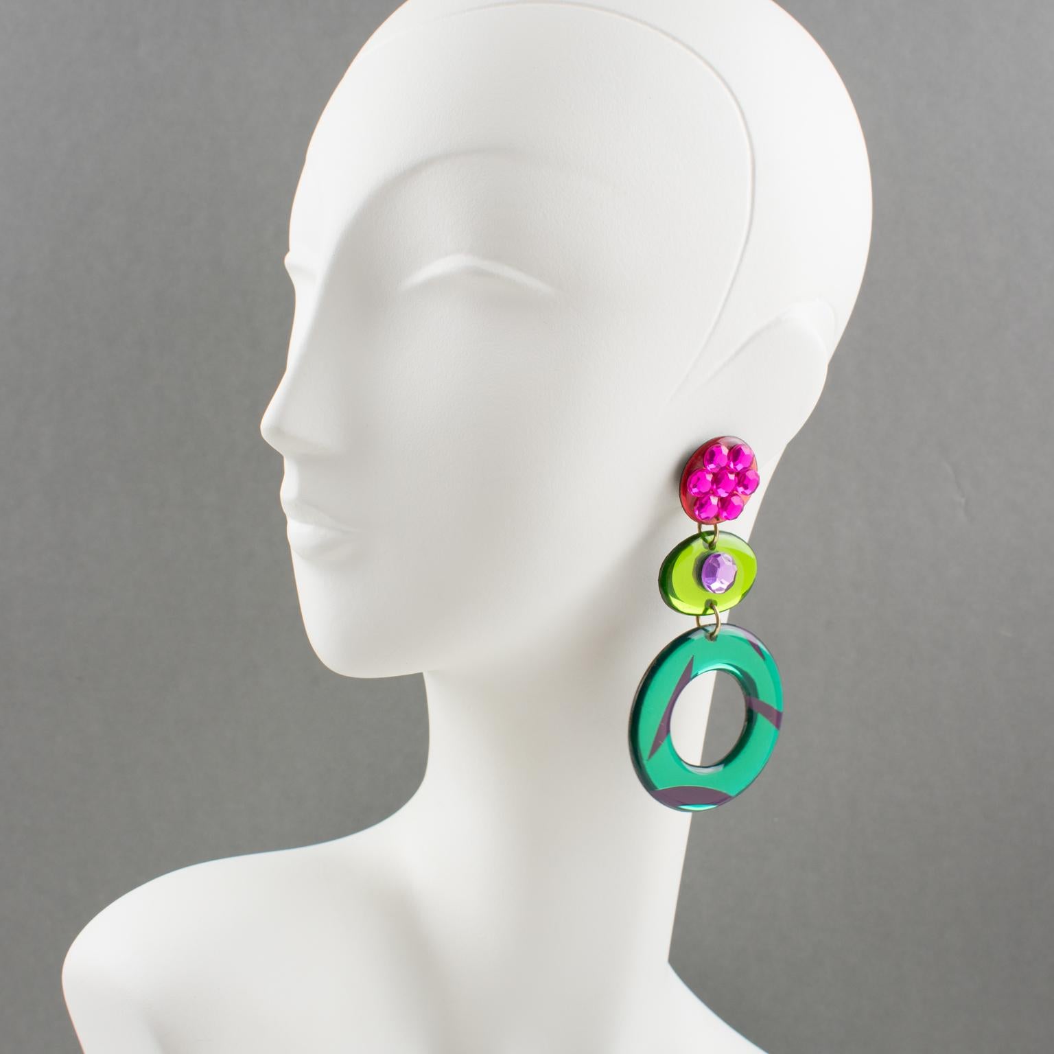Stunning Lucite or Resin dangling clip-on earrings. Oversized chandelier design with ovoid and donut shape in emerald green, apple green, and salmon pink colors with mirror effect and textured pattern. Earrings are ornate with hot pink and light