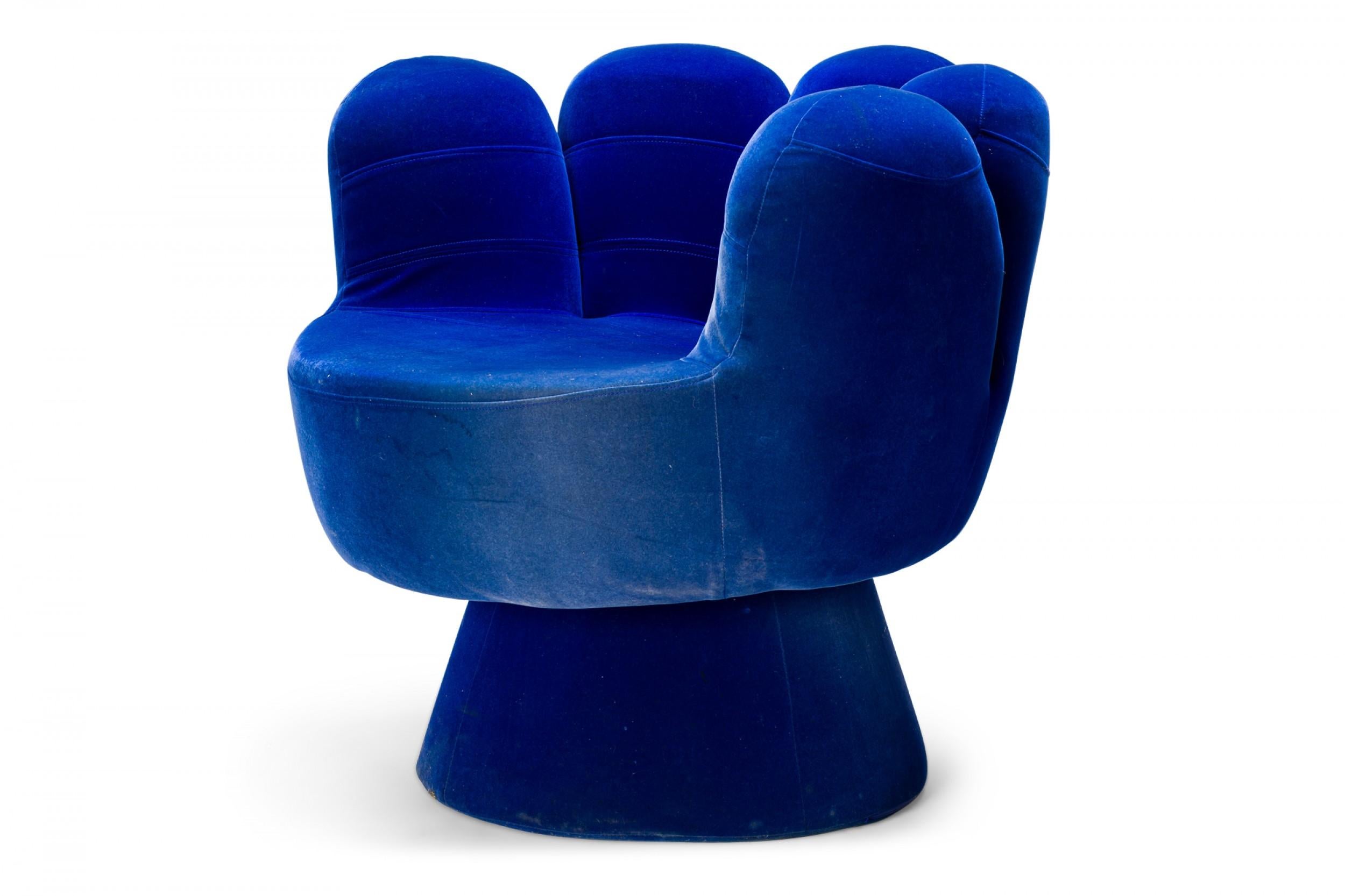 American Mid-Century Pop Art-style 'hand' chair with royal blue velour upholstery and a backrest comprised of five 'fingers' resting on a circular pedestal base.