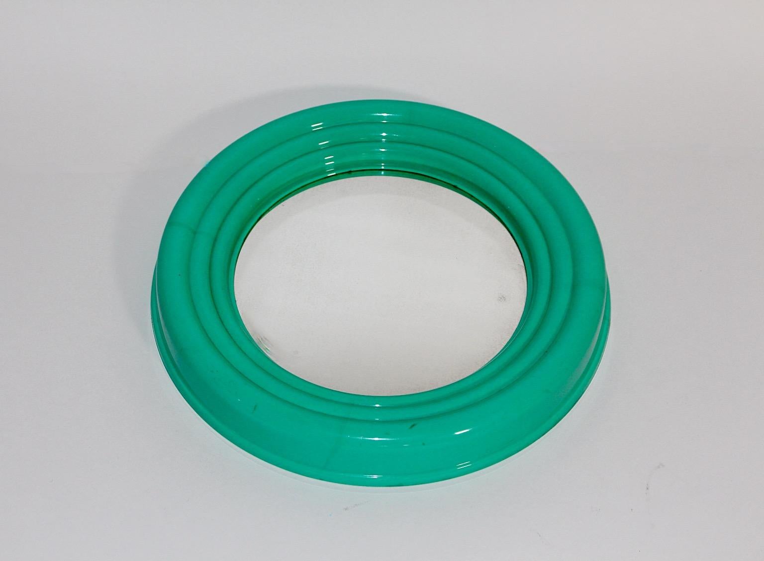 Post-Modern Pop Art style wall mirror circular like from plastic and mirror in bold green teal color 1990s Italy.
A wonderful colorful wall mirror in very good condition with stepped plastic frame and mirror glass.
The wall mirror works perfect as