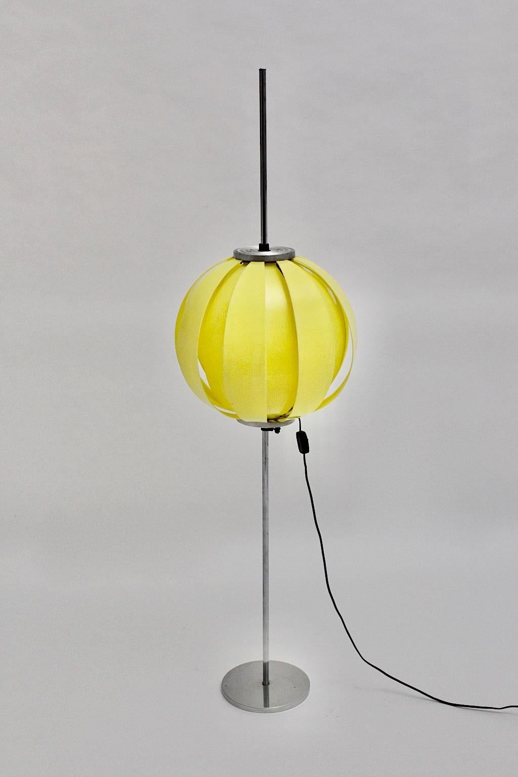 Pop Art Stehlampe aus Kunststoff mit Kugel, entworfen in den 1960er Jahren.
Die sehr dekorative Kunststoffkugel besteht aus 16 gelben, lamellenartigen Kunststoffteilen und der Stiel wurde aus Chrom und Aluminium gefertigt.
Eine Steckdose E 27 und