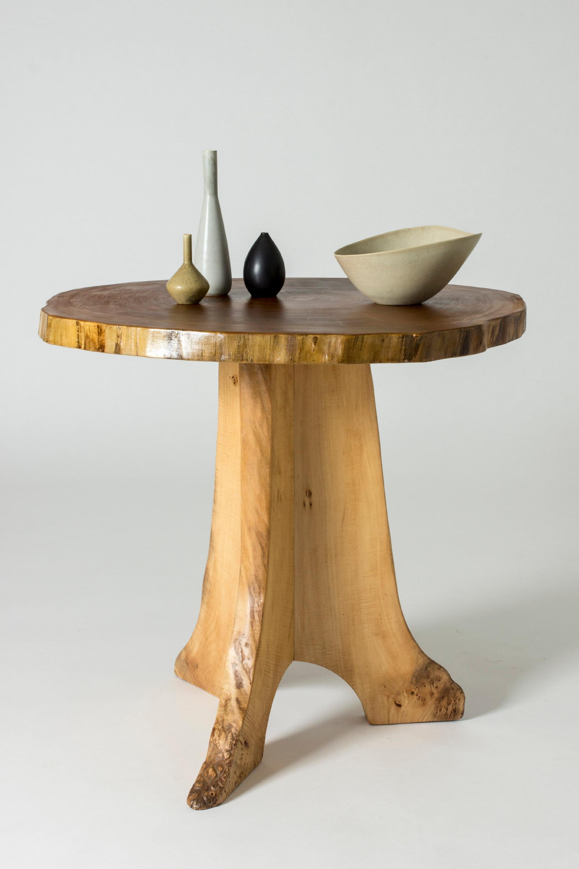 Organic occasional table by Sigvard Nilsson, made from poplar with a piedestal base. The table top is made of a sheet of a tree trunk that shows the annual rings. The base is made from pieces of wood where curves of the tree has been used to create