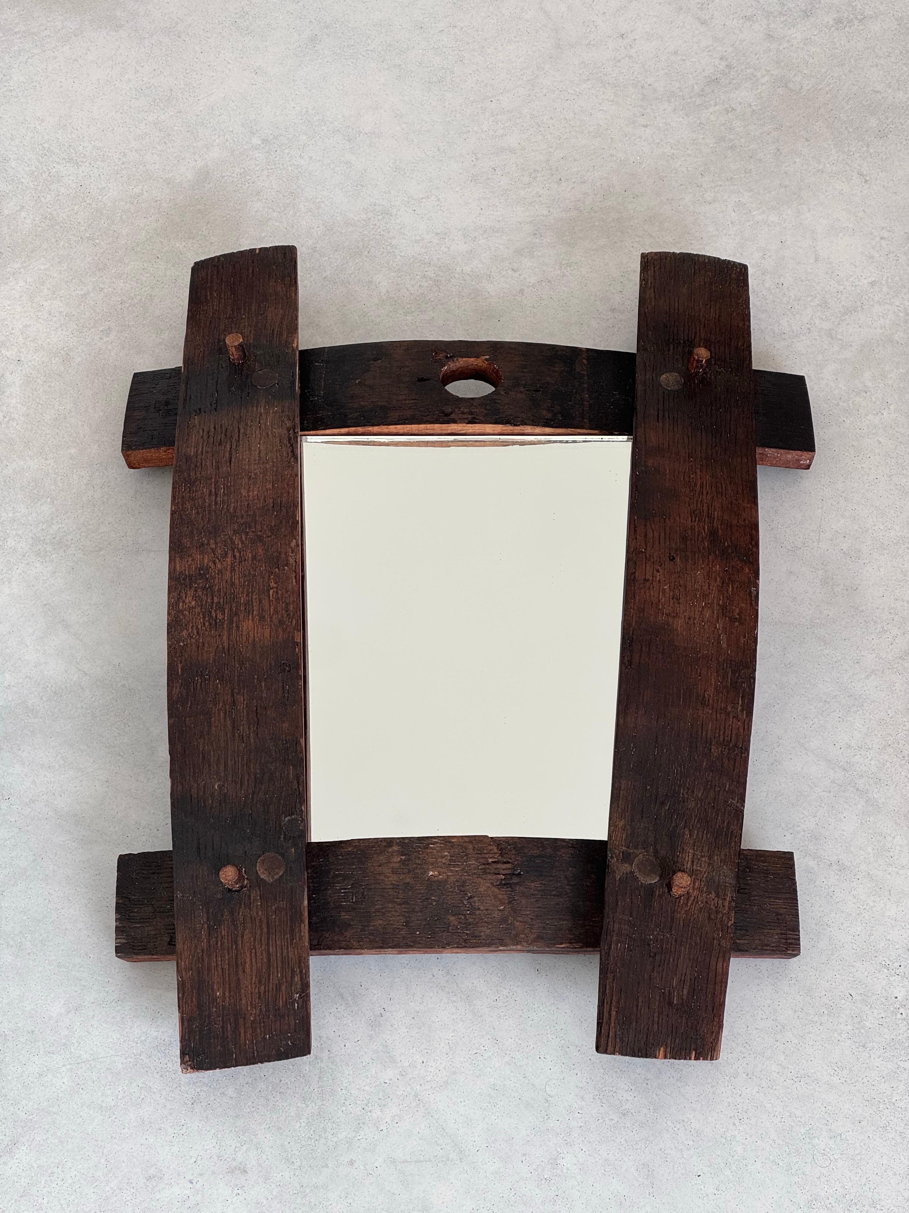 Ce miroir d'art populaire français des années 1950 est une pièce unique et authentique qui incarne le charme rustique et l'artisanat traditionnel. 
Fabriqué en bois massif, il se distingue par son esthétique brute et son caractère intemporel. 
Les