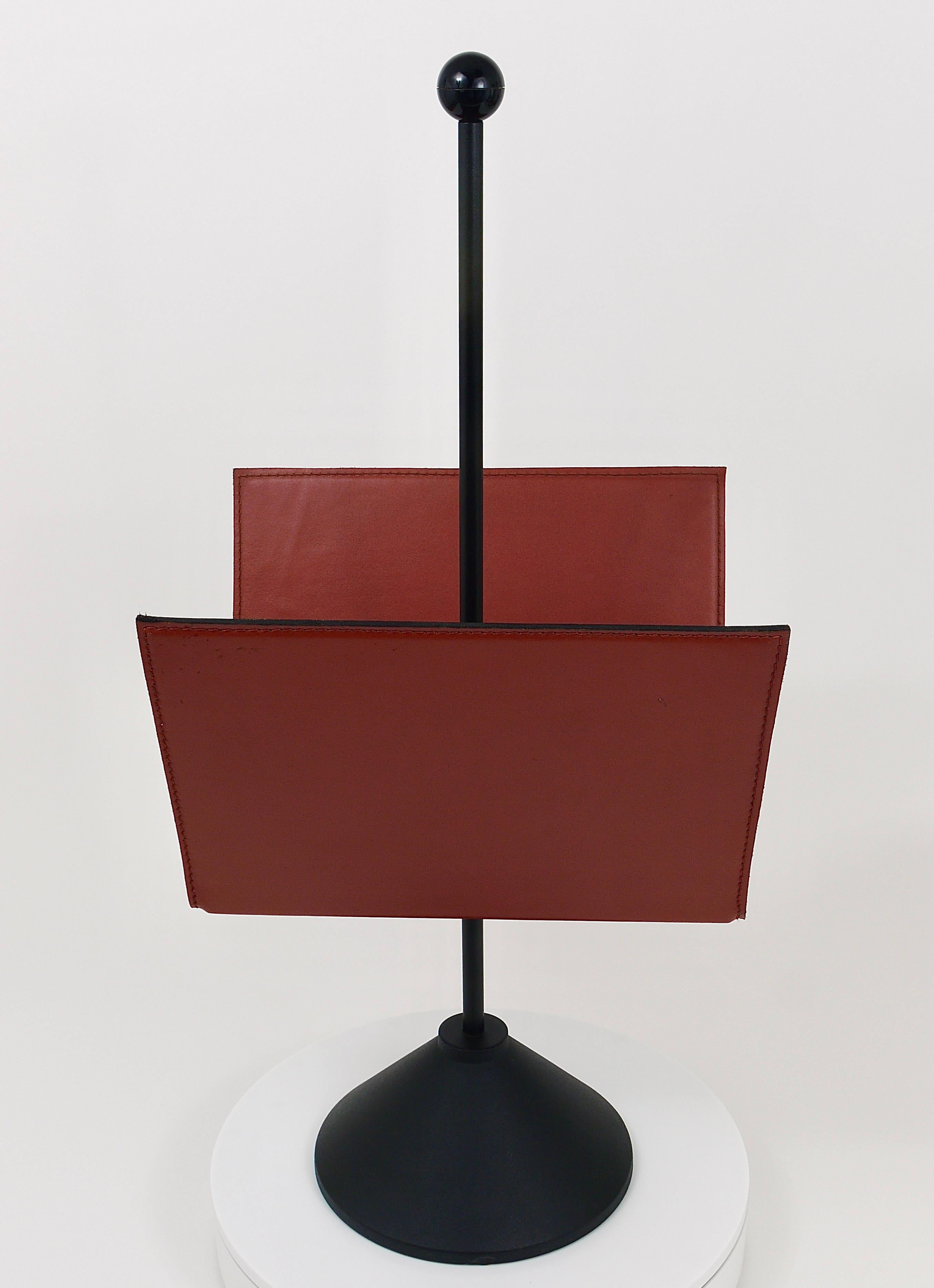 A beautiful post modern minimalist newspaper stand / magazine rack from the 1980s. Manufactured by Porada Arredi, Italy. Made of black metal and cognac brown tan leather, with a solid conical cast iron base and a nice plastic ball on its top. Signed
