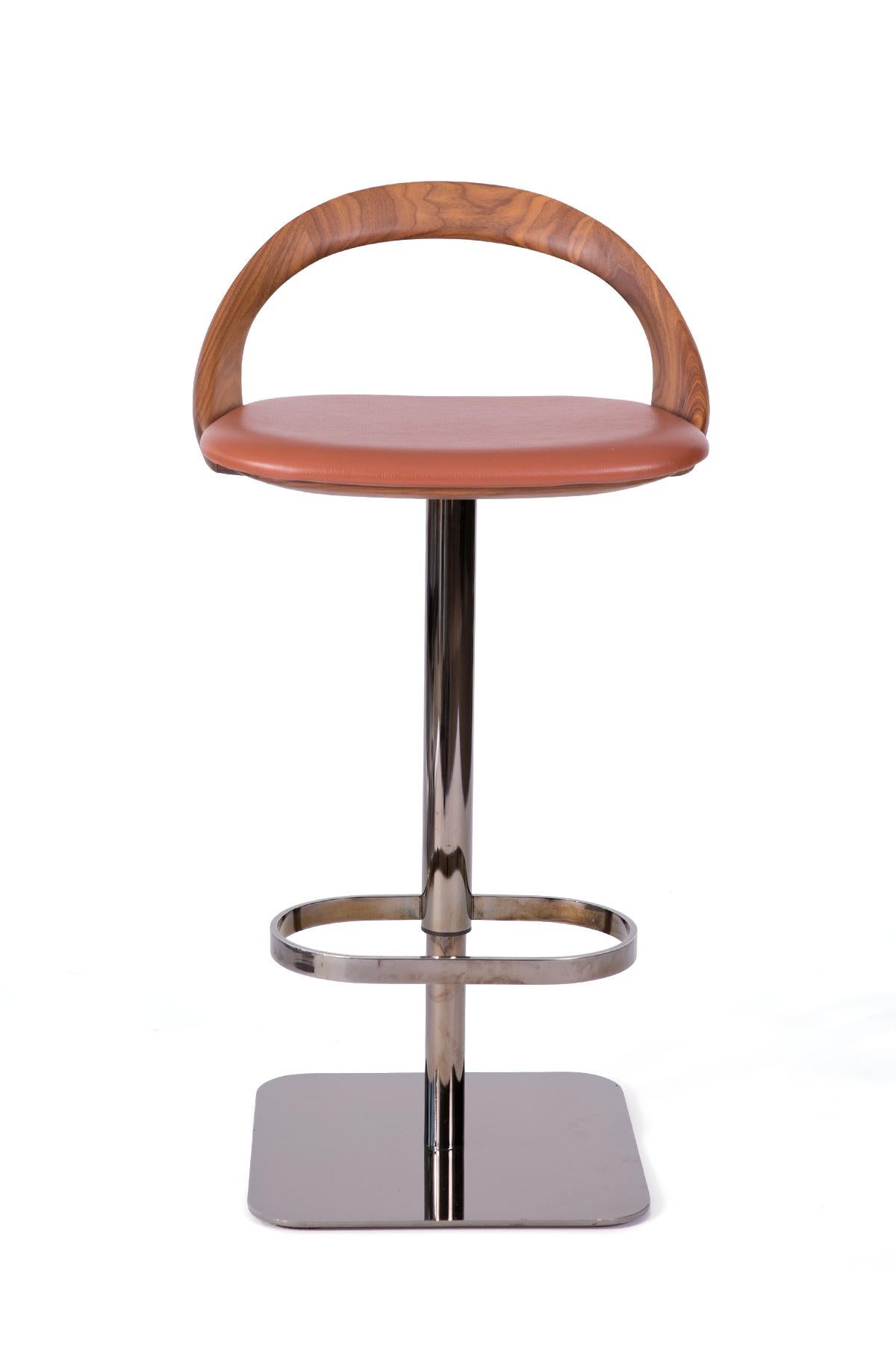 Three ester bar stools designed by Stefano Bigi for Porada are beautifully shaped swiveling bar stools with black chromed bases. The seats feature solid Canaletta walnut frames, gently arching backs and caramel orange leather upholstery. The