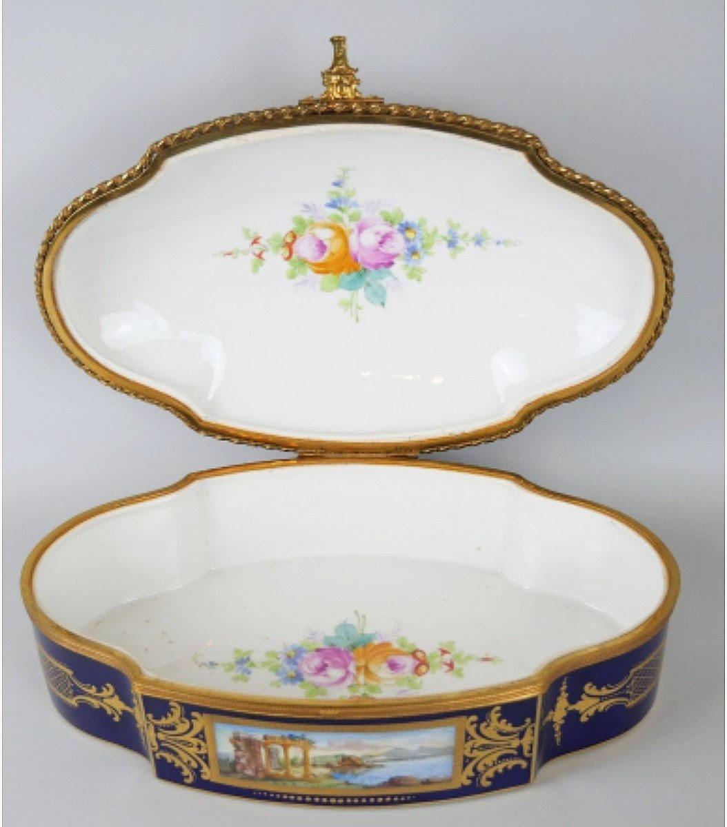Porcelain and gilt bronze box, 19th century.

Porcelain box in painted and gilded porcelain and gilded brass for the frame, very fine decoration, signed Latour.  
H: 15cm, W: 40cm, D: 26cm