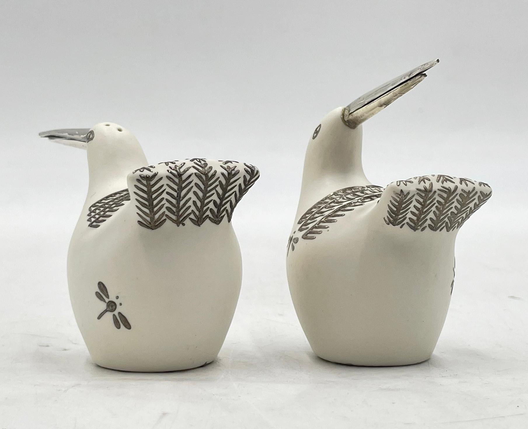 A charming and whimsical set of handcrafted salt and pepper shakers by renowned Mexican designer Emilia Castillo. Made in Taxco, this sculptural pair is crafted in white porcelain with intricate silver overlay details and beaks made from pure (.925)