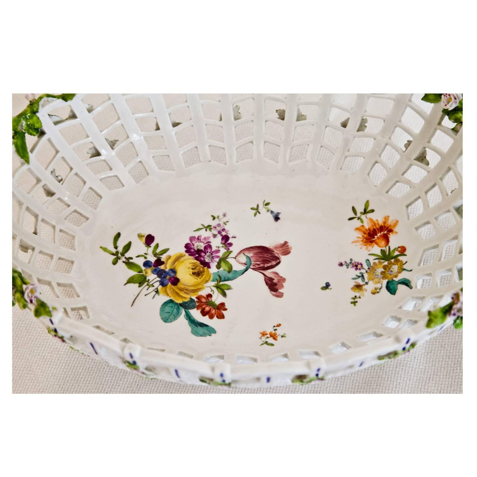 Oval porcelain basket with handles by KPM Berlin with plastic flower décor on the pierced rim and a polychrome flower bouquet on the well.