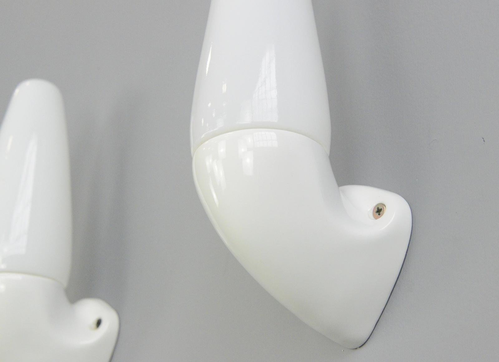 Porcelain bathroom lights by Sigvard Bernadotte for Ifo, circa 1950s

- Price is per pair 
- Vitreous white porcelain wall mounts
- Screw off opaline shades
- Takes E27 fitting bulbs
- Wires directly into the wall
- Designed by Sigvard