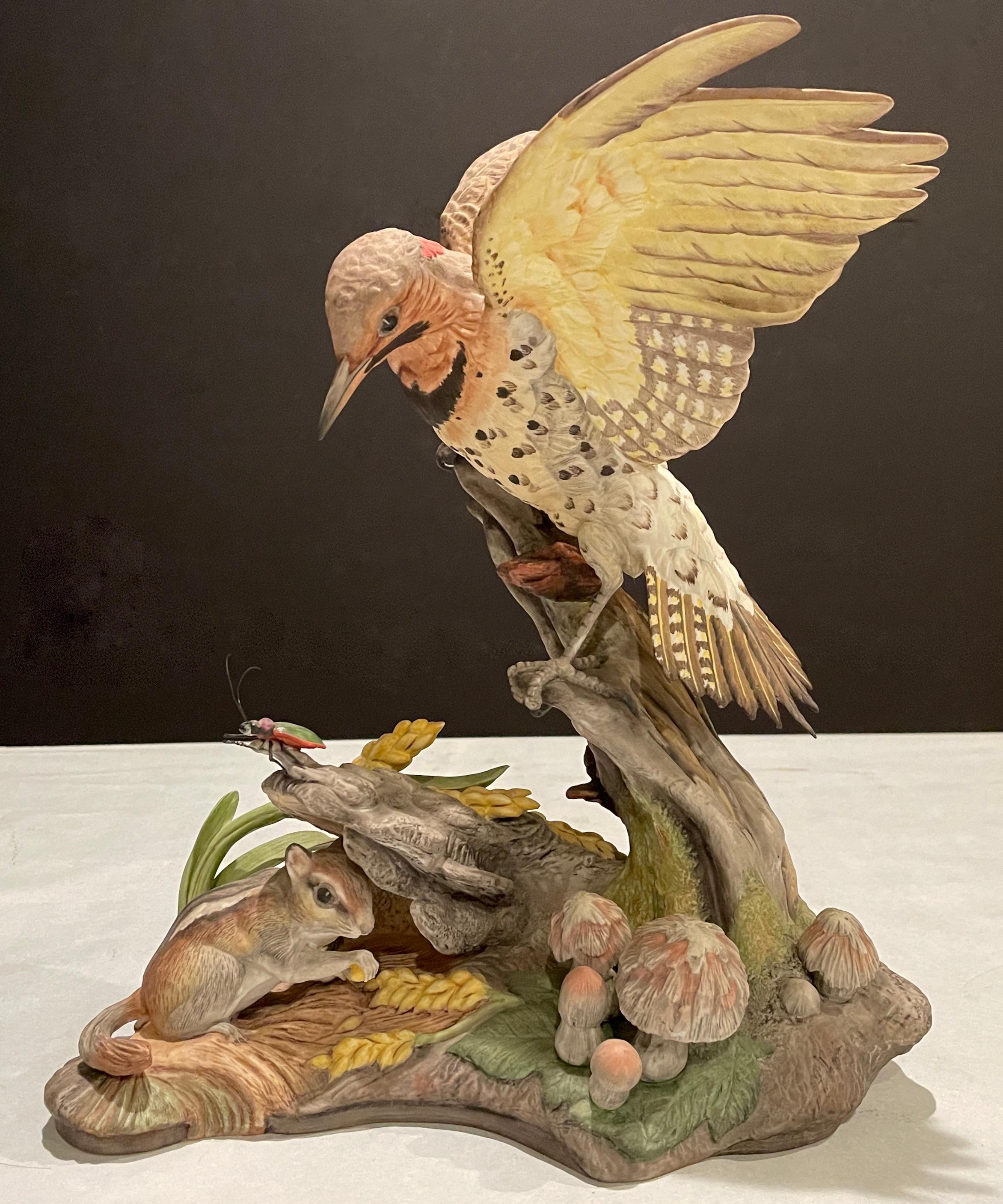 Intricate limited edition Boehm bird scuplture - Bisque porcelain figure depicts a Yellow Shafted Flicker on a branch over an insect while a small chipmunk picks at a wheat sheaf under the branch. Boehm porcelain Yellow Shafted Flicker #400-16. This