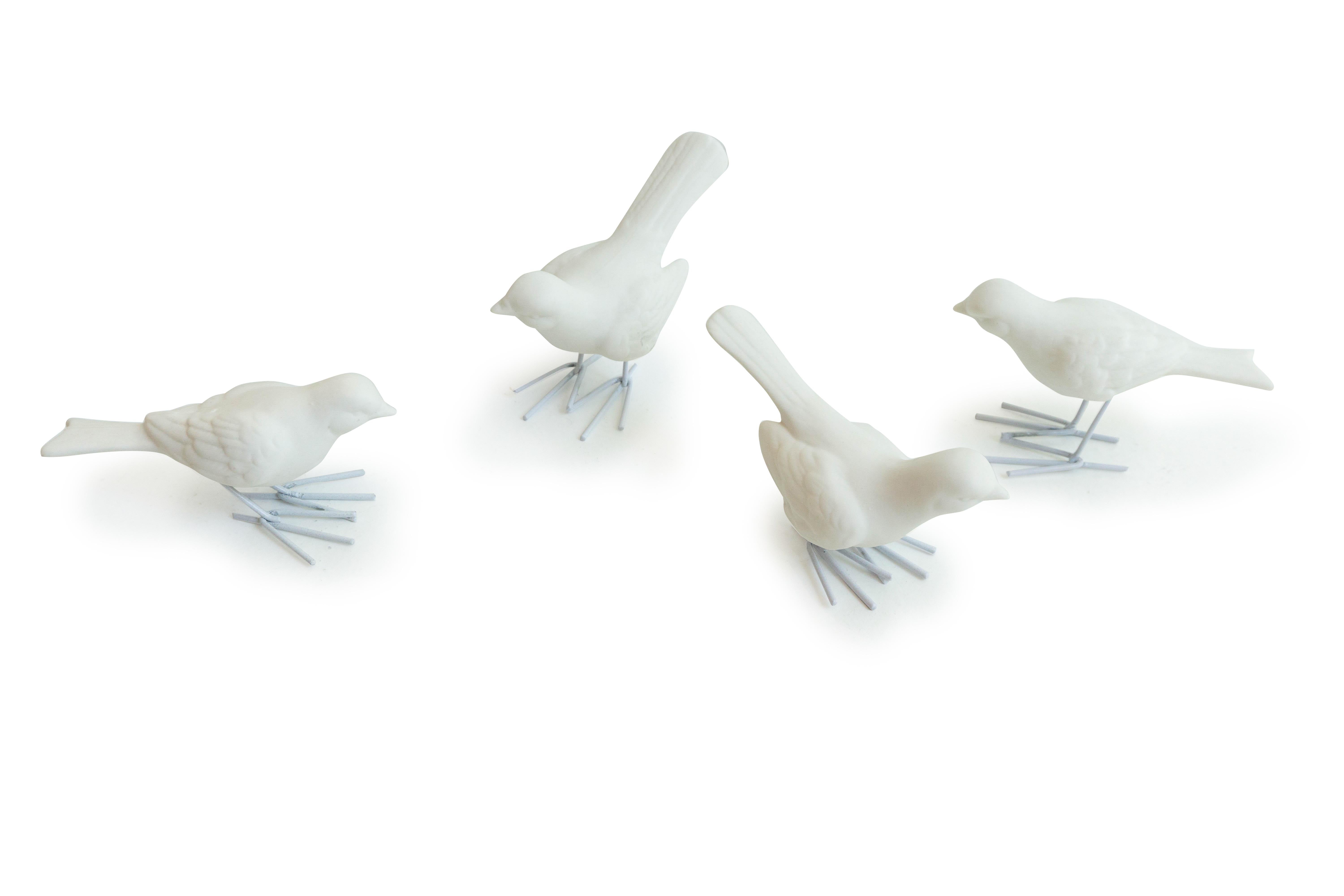 A set of four unglazed white porcelain Starlings with iron legs. Perched throughout your space for a year round decoration. 

Dimensions: 5” H x 2” W x 4” L