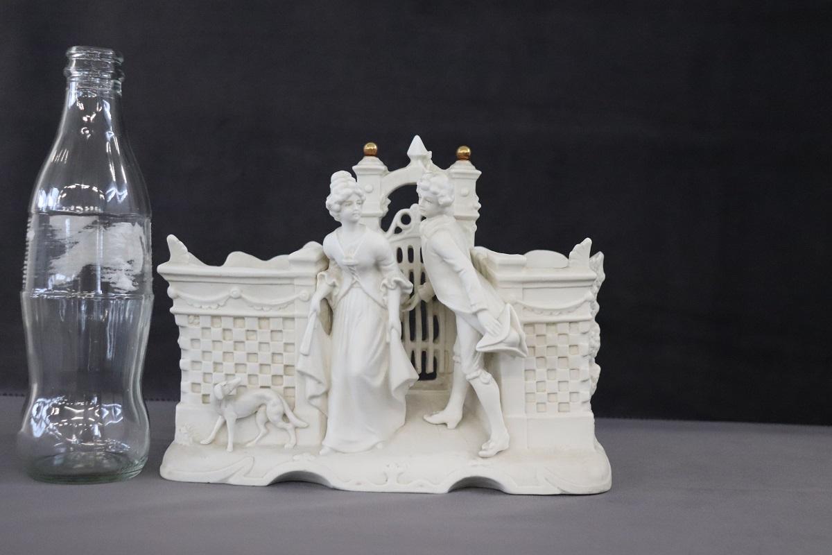 This pen holder is truly refined, made of biscuit porcelain. Elaborate decoration with a loving couple on the front. Two compartments for pens. Perfect for a refined desk.