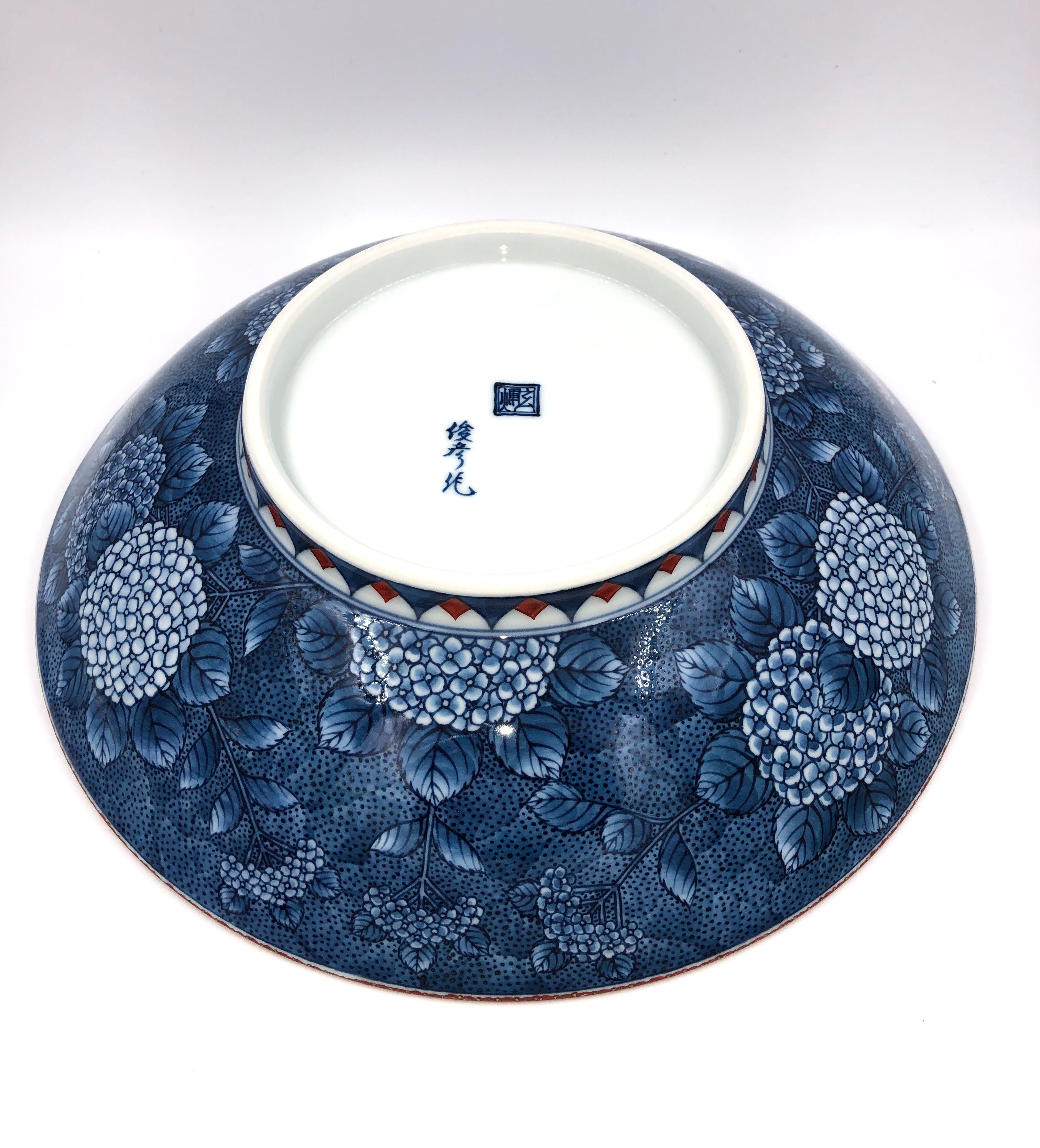 Unique Japanese contemporary decorative porcelain decorative bowl, intricately gilded and hand painted in red, purple and blue on an elegantly shaped round body, a signed masterpiece by second-generation master porcelain artist of the Imari-Arita