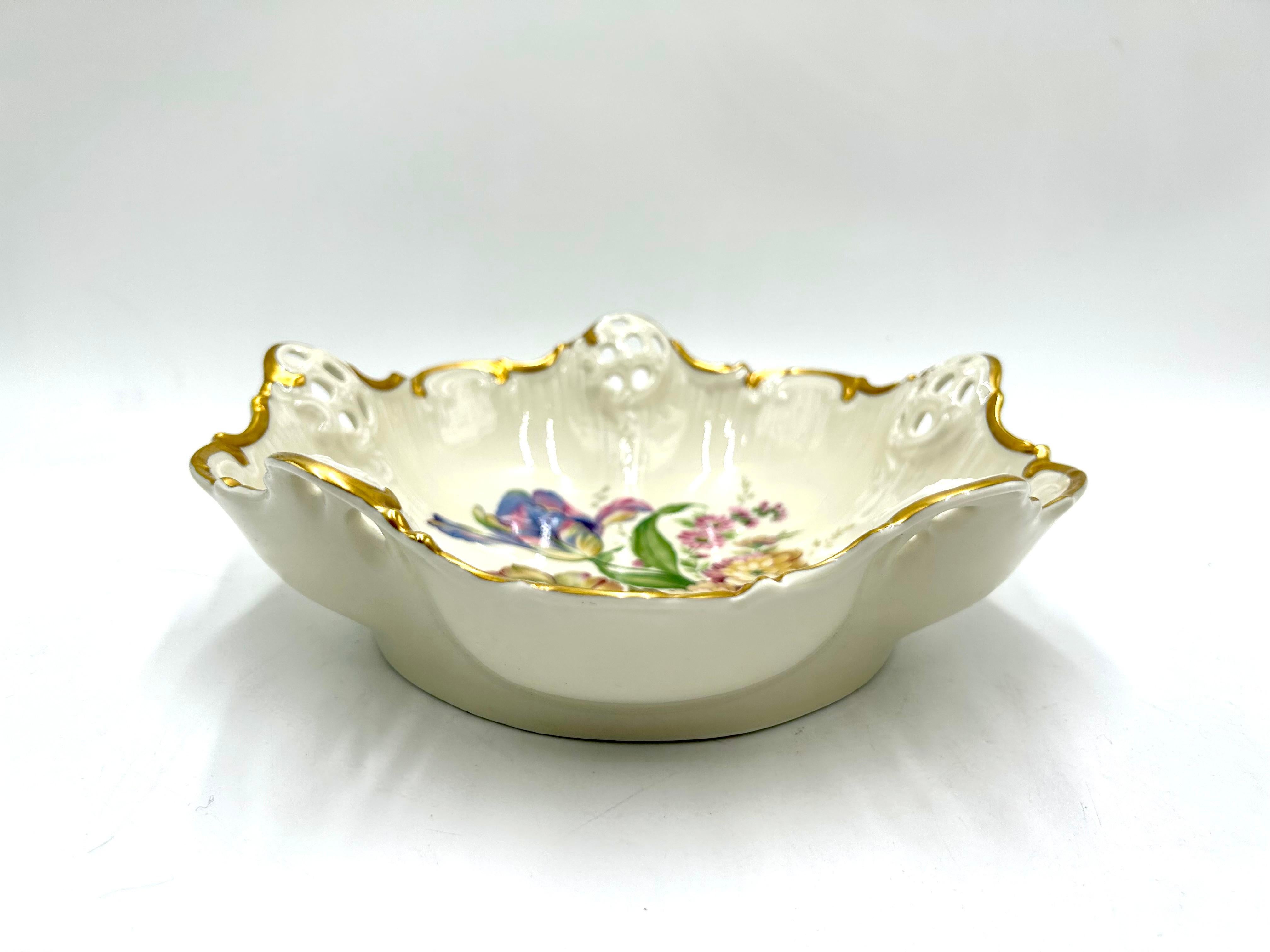 Porcelain openwork bowl made of ecru porcelain, decorated with gilding and a bouquet of flowers motif. A product of the valued German manufacturer Rosenthal from the Moliere series with the Millefleurs decoration pattern. Signed with the mark used