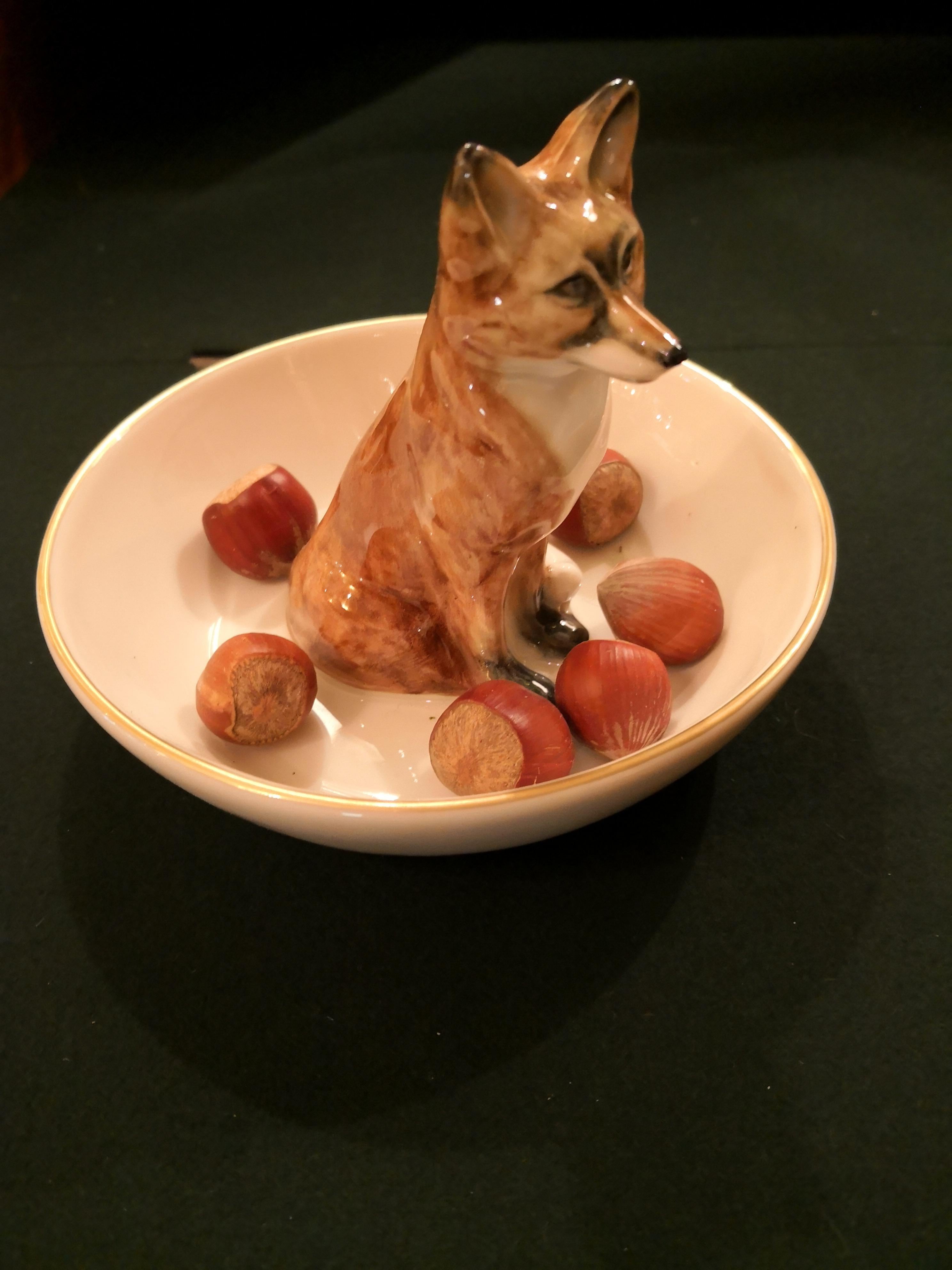 Completely handmade porcelain bowl with a hands-free naturalistic painted fox in brown colors. The fox is sitting in the middle of the bowl for decorating nuts or sweets around the fox figure. Rimmed with a fine 24 carat gold line. Handmade in