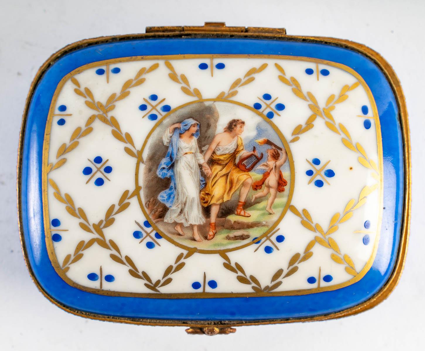 Porcelain box, late 19th - early 20th century.

Porcelain box from the end of the 19th century or beginning of the 20th century, gilded brass, very nice painted scene with gold decoration.

Measures: H: 5 cm, W: 12.5 cm, D: 10 cm.