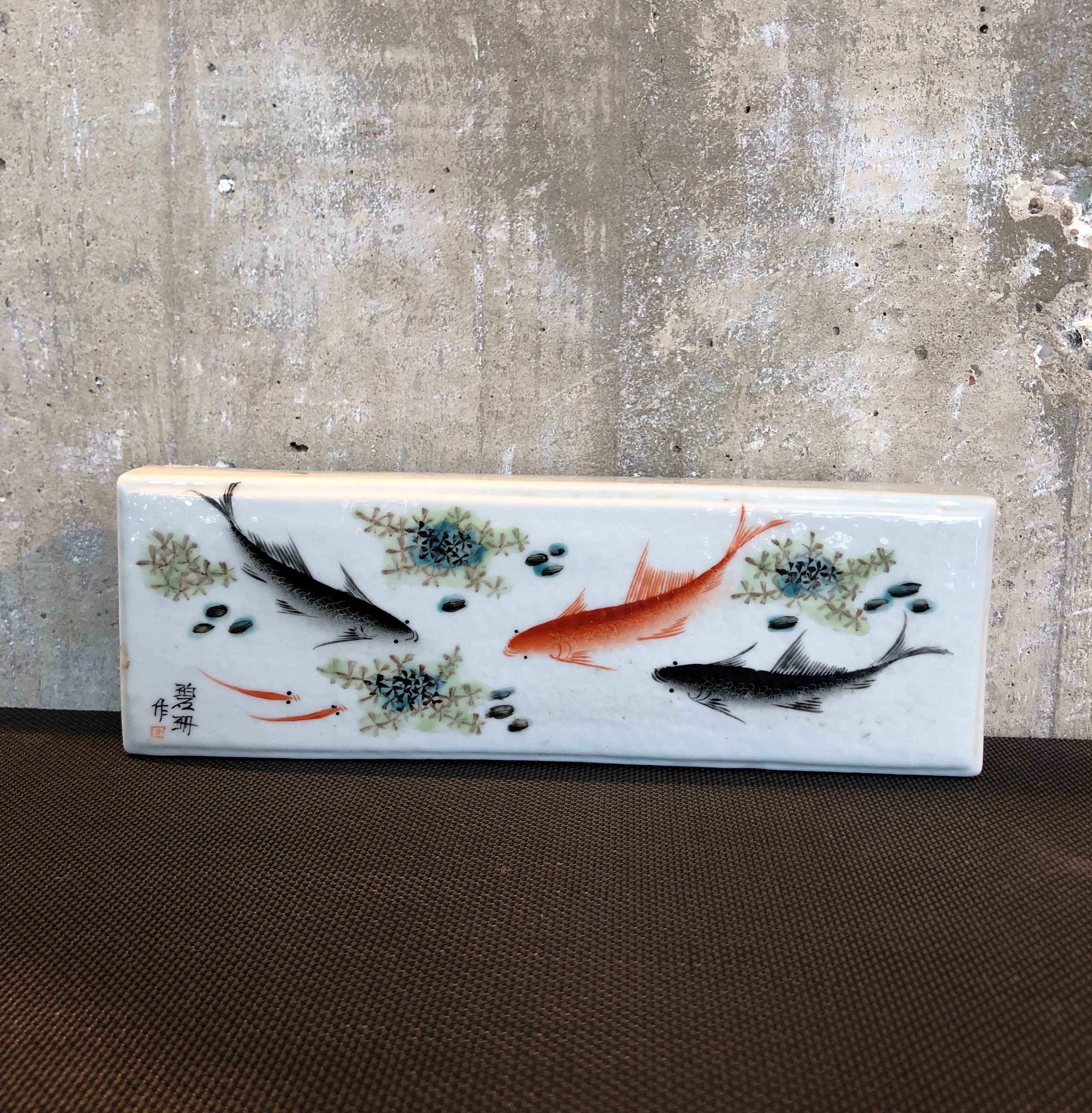 A heavy mid-century Chinese porcelain brush rest, beautifully hand painted with colorful fish images and character marks on the lower left corner. An unusual and striking piece.