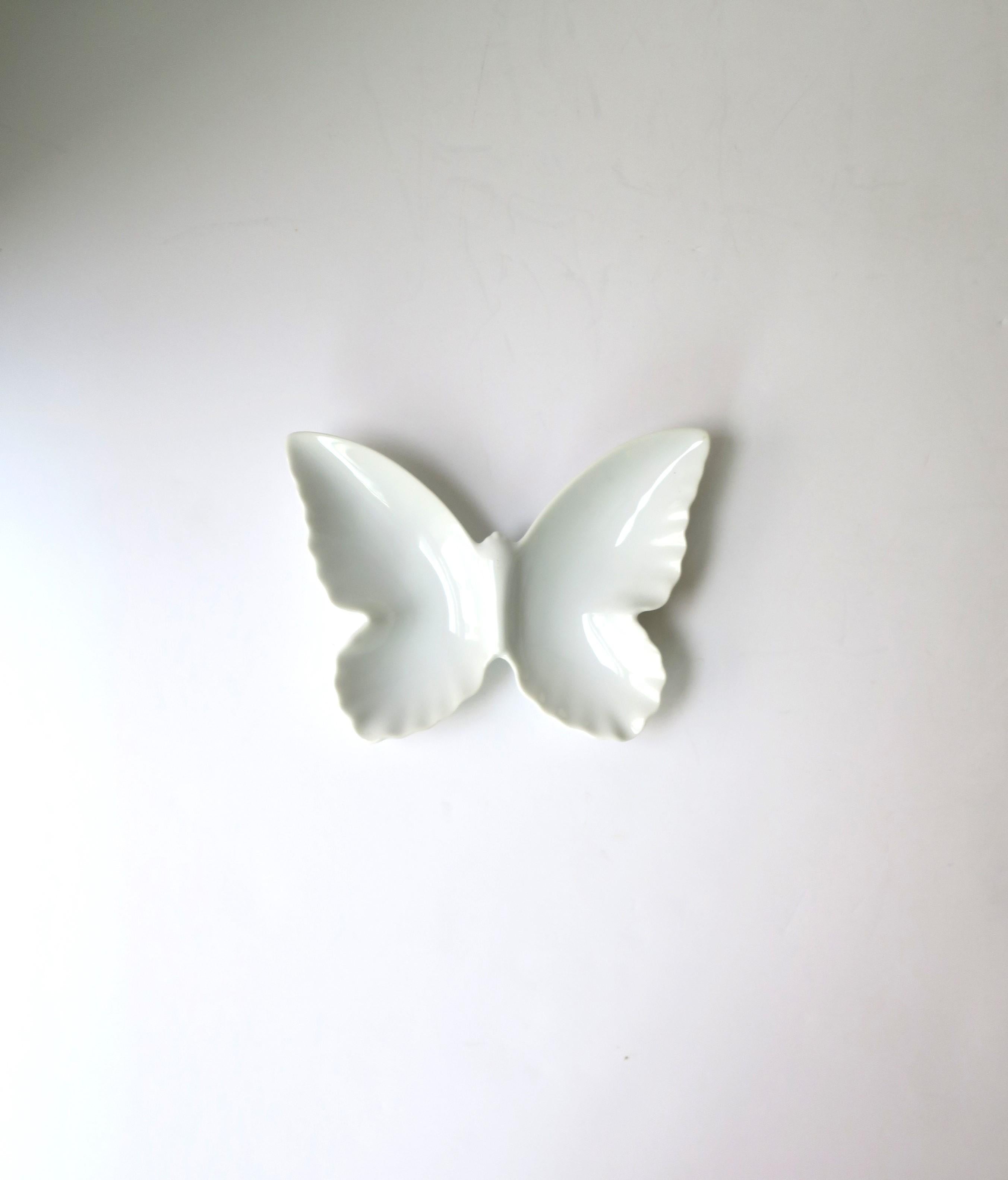 A white porcelain butterfly jewelry dish vide-poche, circa mid to late-20th century. A great piece for a desk, vanity, nightstand table, dresser, etc., to hold jewelry (as demonstrated) or other small items. Dimensions: 4.57