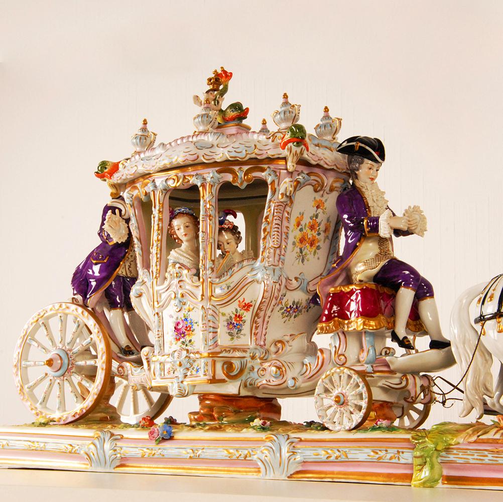 Sächsische Porzellanfigurengruppe - Porzellankutsche
Volkstedter Porzellankutsche mit dem Titel Königliche Prinzessinnenfahrt
Darstellung einer höfischen Szene.
Die Liege besteht aus 2 Teilen mit einem abnehmbaren Dach.
In der Kutsche zwei königlich