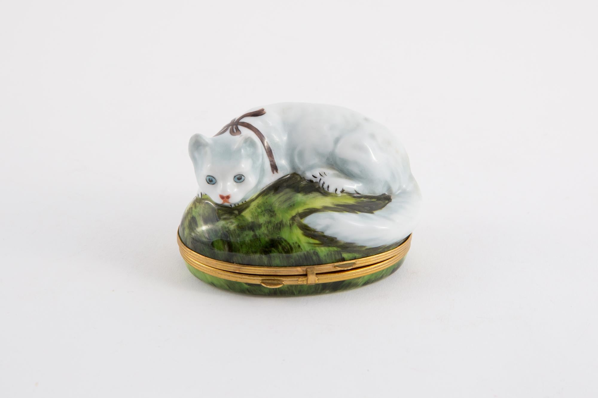 Porcelain pill box and metal frame decorated with a raised cat and mouse decoration inside the box. Had printed. Signed L.C
In excellent vintage condition. Made in France. 
Height 2.3in. (6cm)
Length 3.1in. (8cm)
We guarantee you will receive this