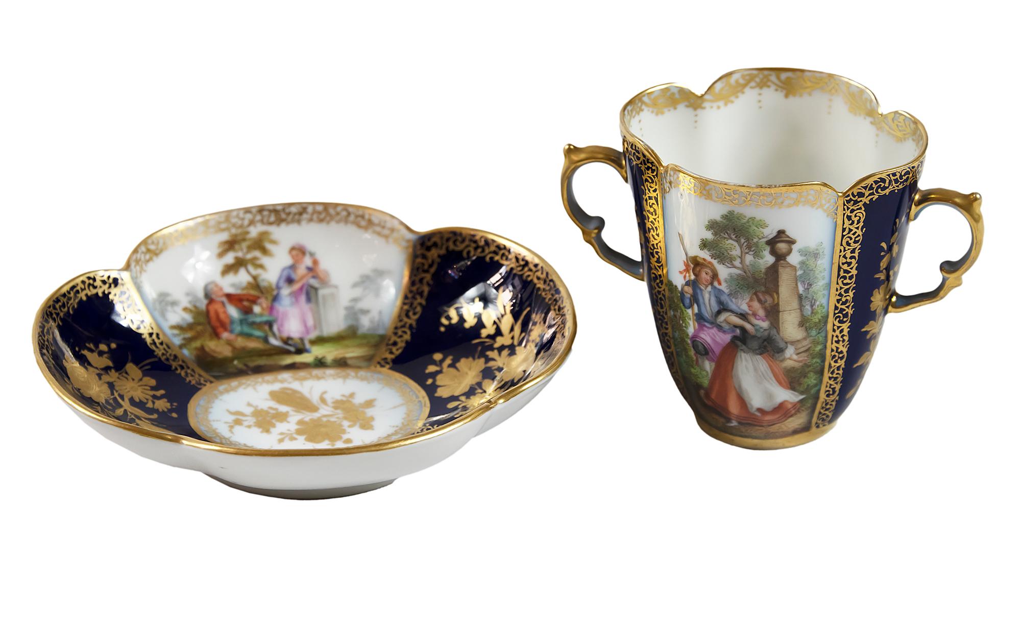 Antique porcelain Augustus Rex Helena Wolfsohn chocolate cup with saucer decorated with cobalt, gold and hand painted romantic scenes.
Measures:
Cup: 8.2 (H) x 11.5 x 7 cm
Saucer: 3 (H) x 14 x 12.5 cm.

      