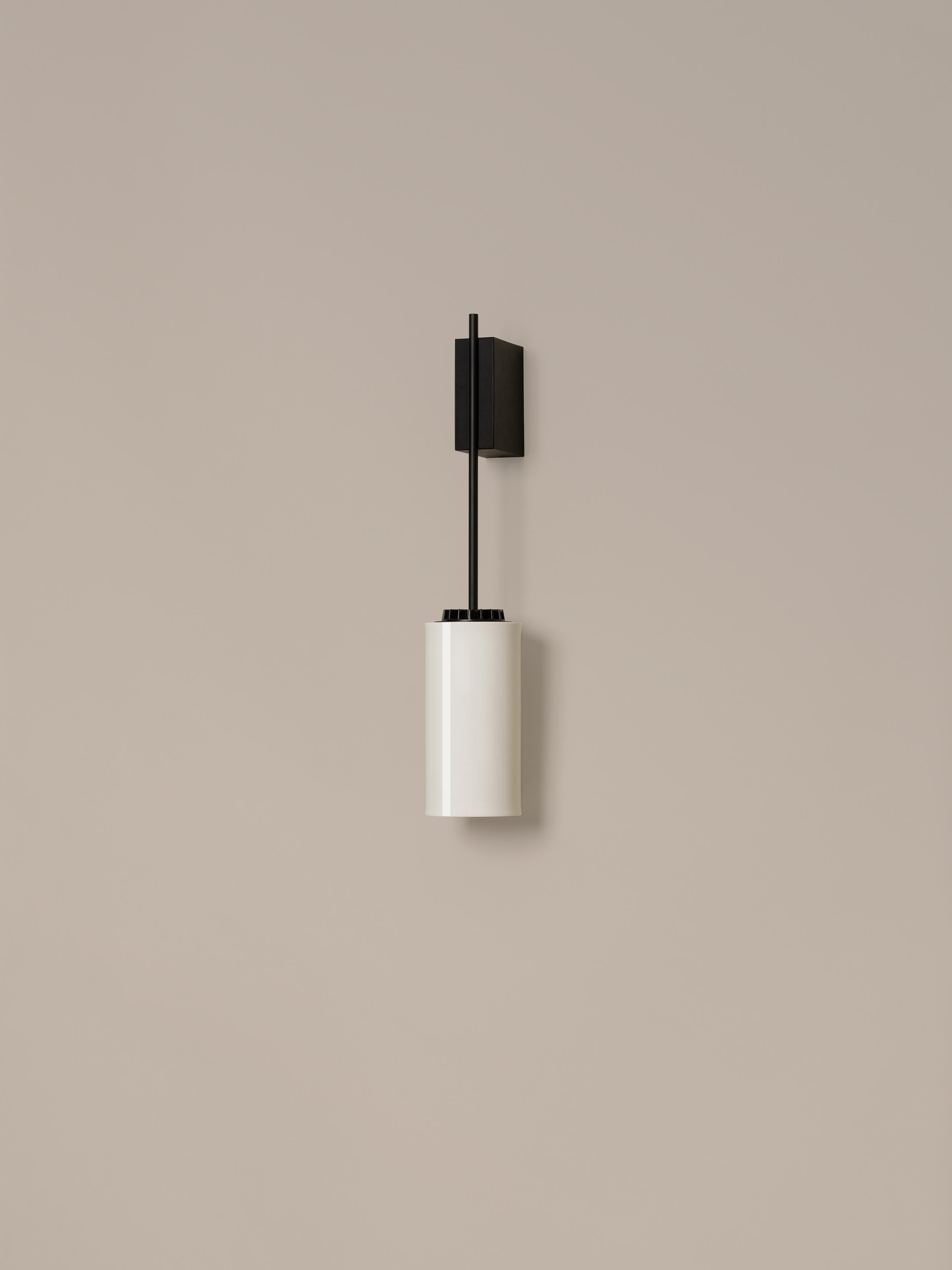 Porcelain Cirio wall lamp by Antoni Arola
Dimensions: D 10 x W 14 x H 54 cm
Materials: Metal, porcelain.

The wall version of Cirio allows the light to be placed at a closer scale to the user. This creates a succession of rhythms that, in