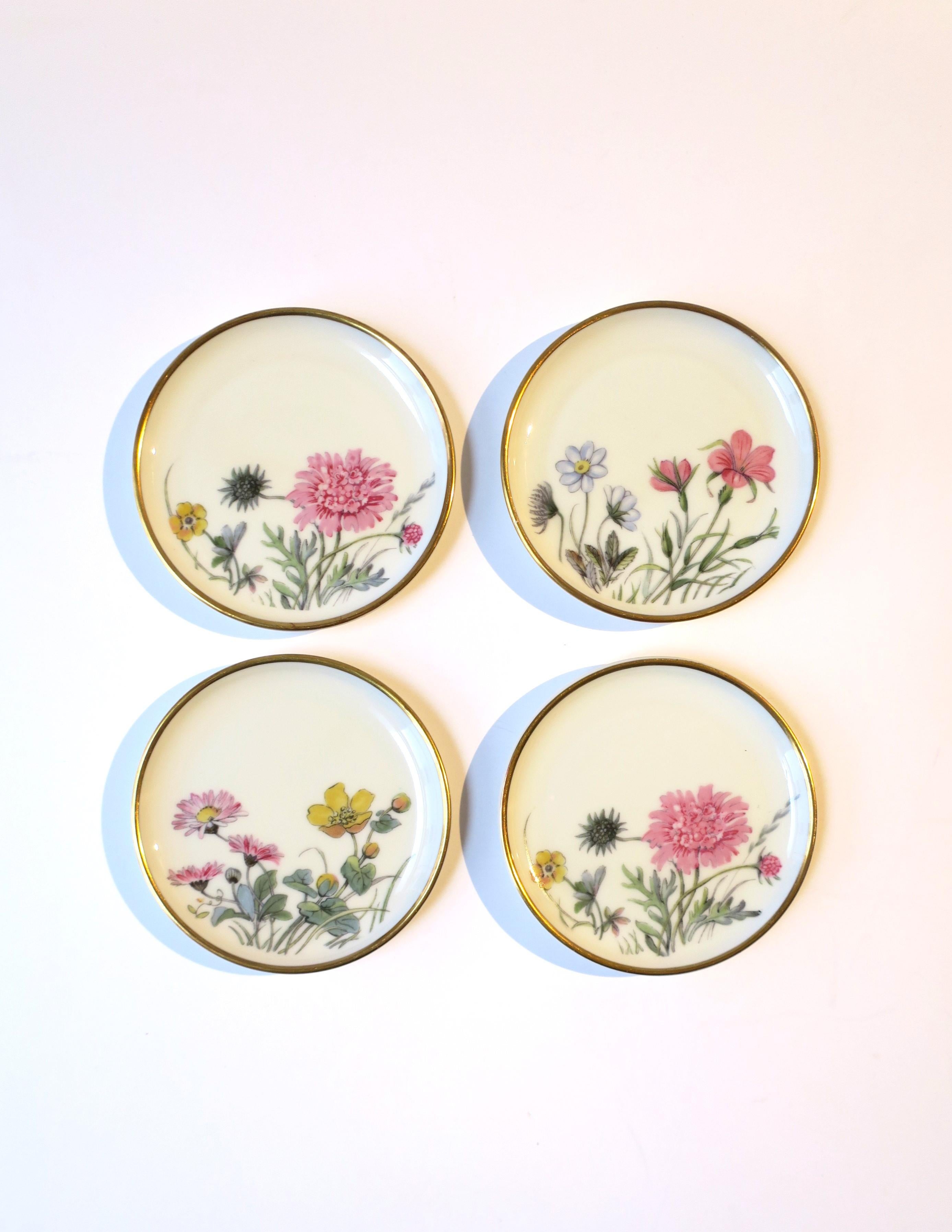 A very beautiful set of four (4) German off-white porcelain cocktail drinks coasters with botanical design and gold trimmed edge, circa mid-20th century, Germany. Colors include pink, yellow, blue, green, and gold. A beautiful set and essential for