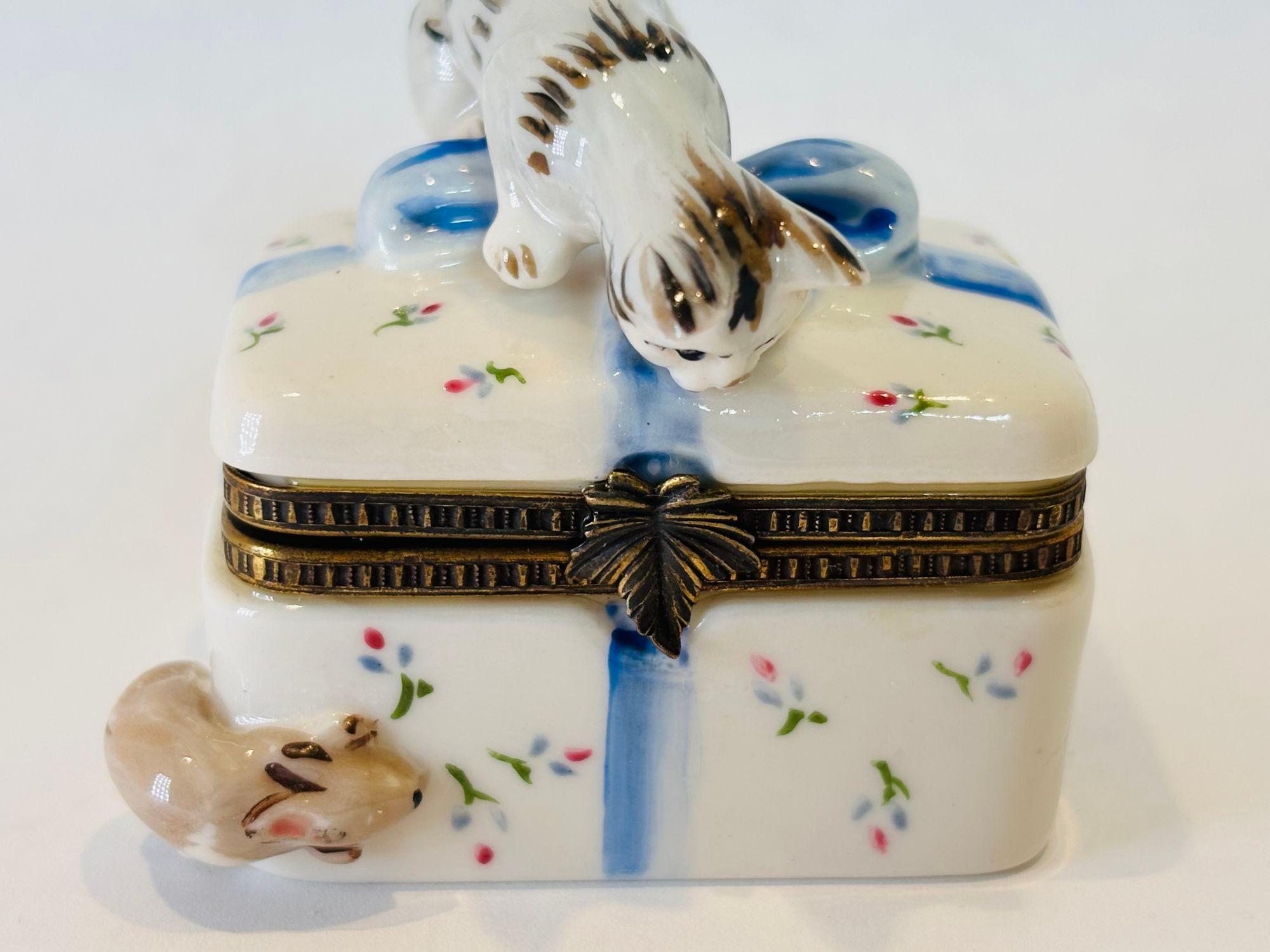 Caja de porcelana coleccionable, exquisita pieza de Arte artesanal figura de caja decorativa con un gato en la parte superior y un ratón en la esquina inferior.
Studio USA es un conocido fabricante de objetos de porcelana fina, como cajas
