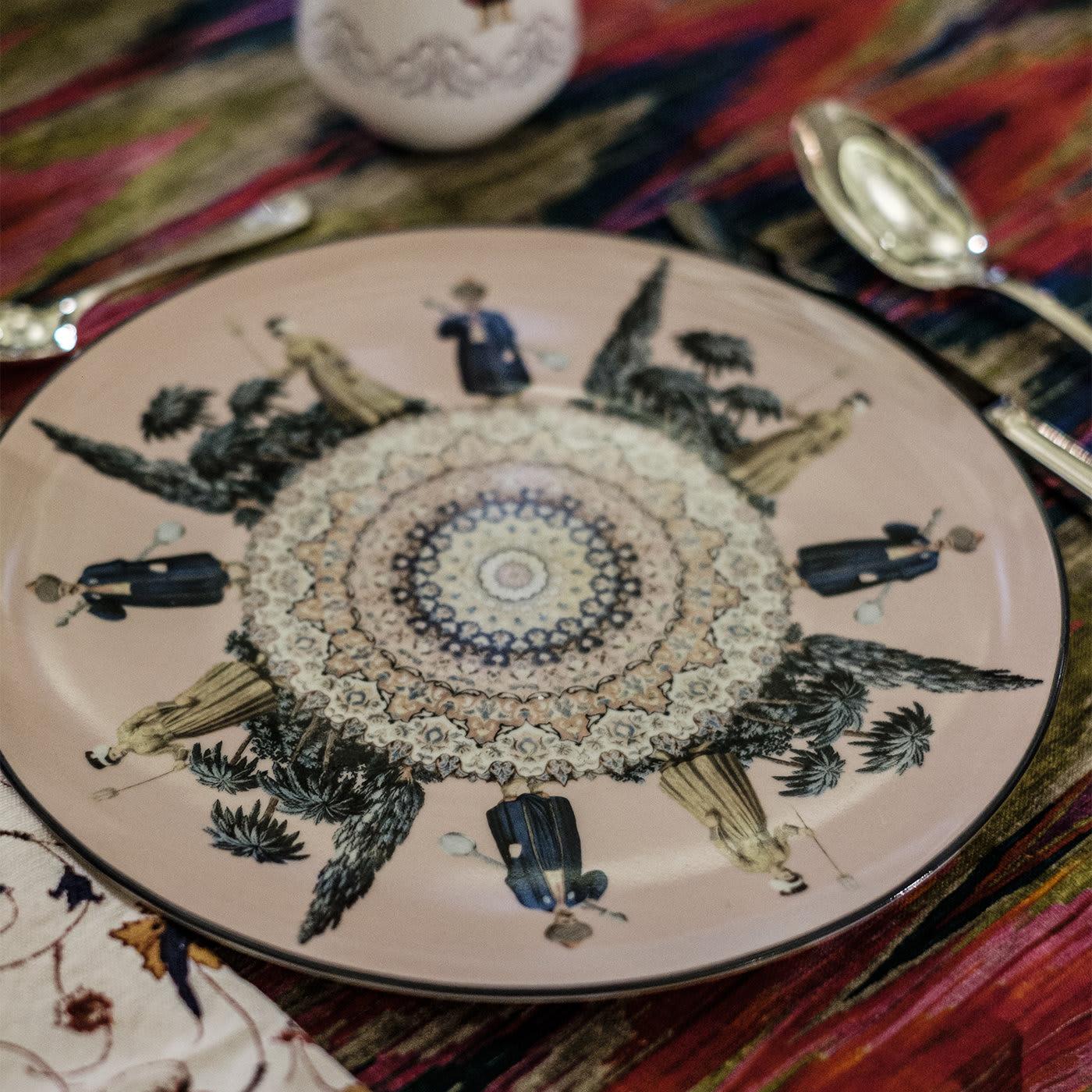 This exquisite porcelain dinner plate was designed by Vito Nesta and evokes a fantastical world inspired by the Ottoman Empire. In this piece, the background is in a delicate shade of pink, complemented by the deep blue rim that runs all around the
