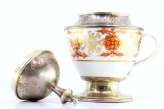 Porcelain cup w/ silver knob on the lid & circular base w/ surrounding frieze