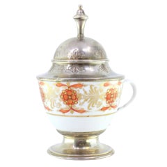 Porcelain cup w/ silver knob on the lid
circular base w/ surrounding frieze