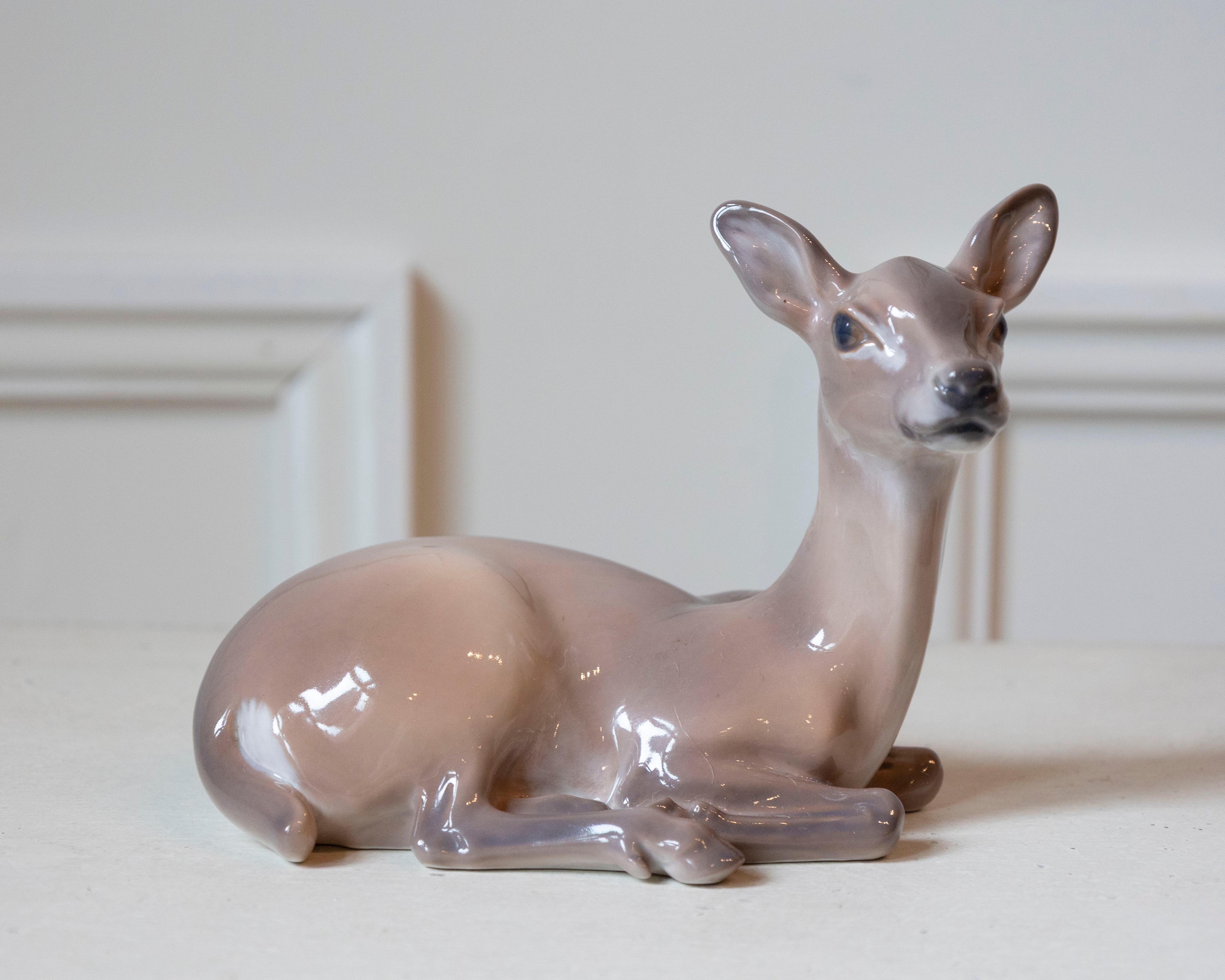 An exquisite porcelain deer by Danish sculptor Dahl Jensen, celebrated for his masterful naturalism and refined craftsmanship. Produced in Copenhagen during the mid-20th century, this piece captures the quiet elegance of a resting deer with