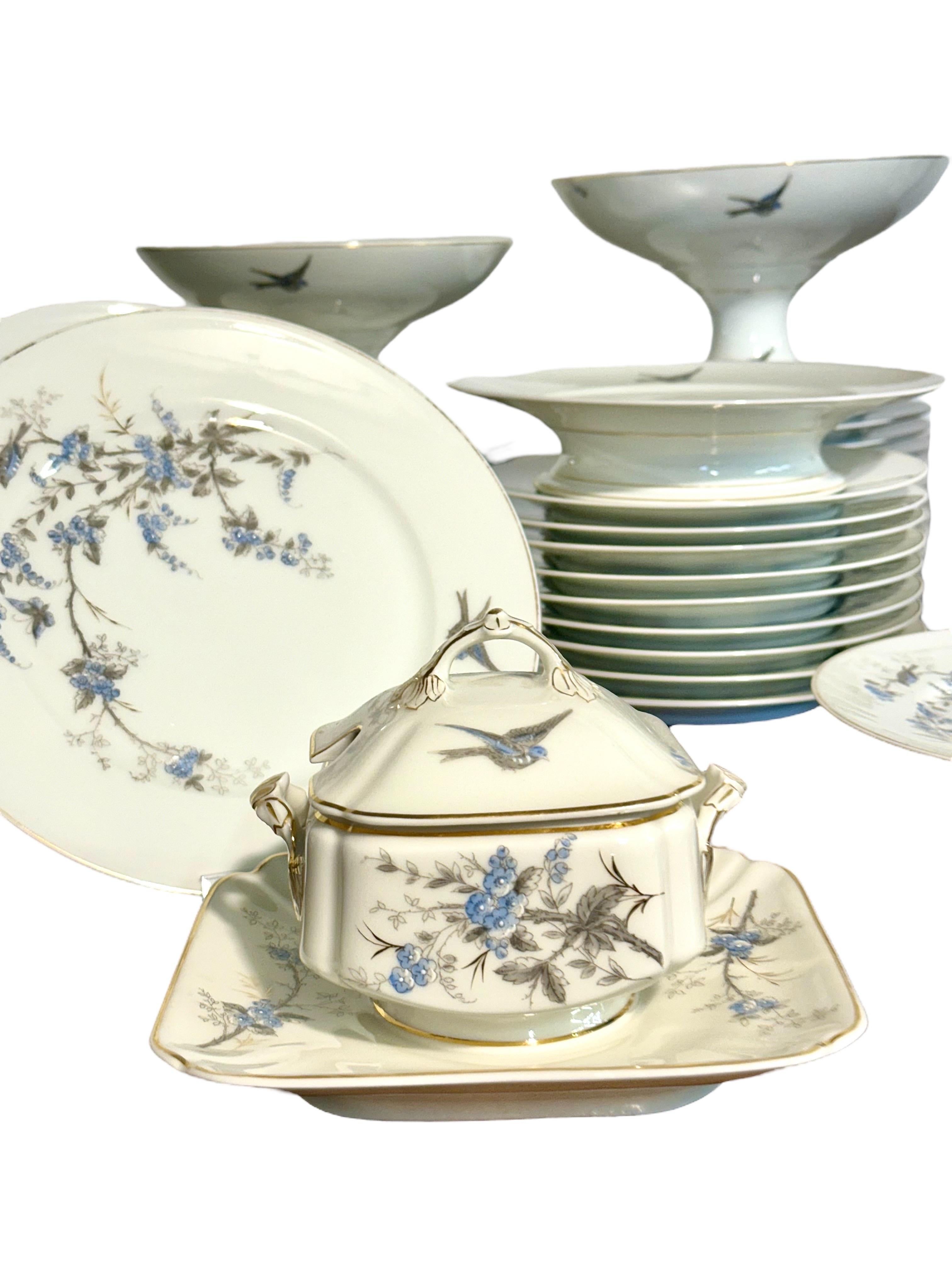 Ce remarquable service de table en porcelaine de 43 pièces date de la fin du XIXe siècle et reflète magnifiquement le goût raffiné de l'époque. Chaque pièce est délicatement décorée de gerbes de fleurs bleues peintes à la main et de gracieux oiseaux