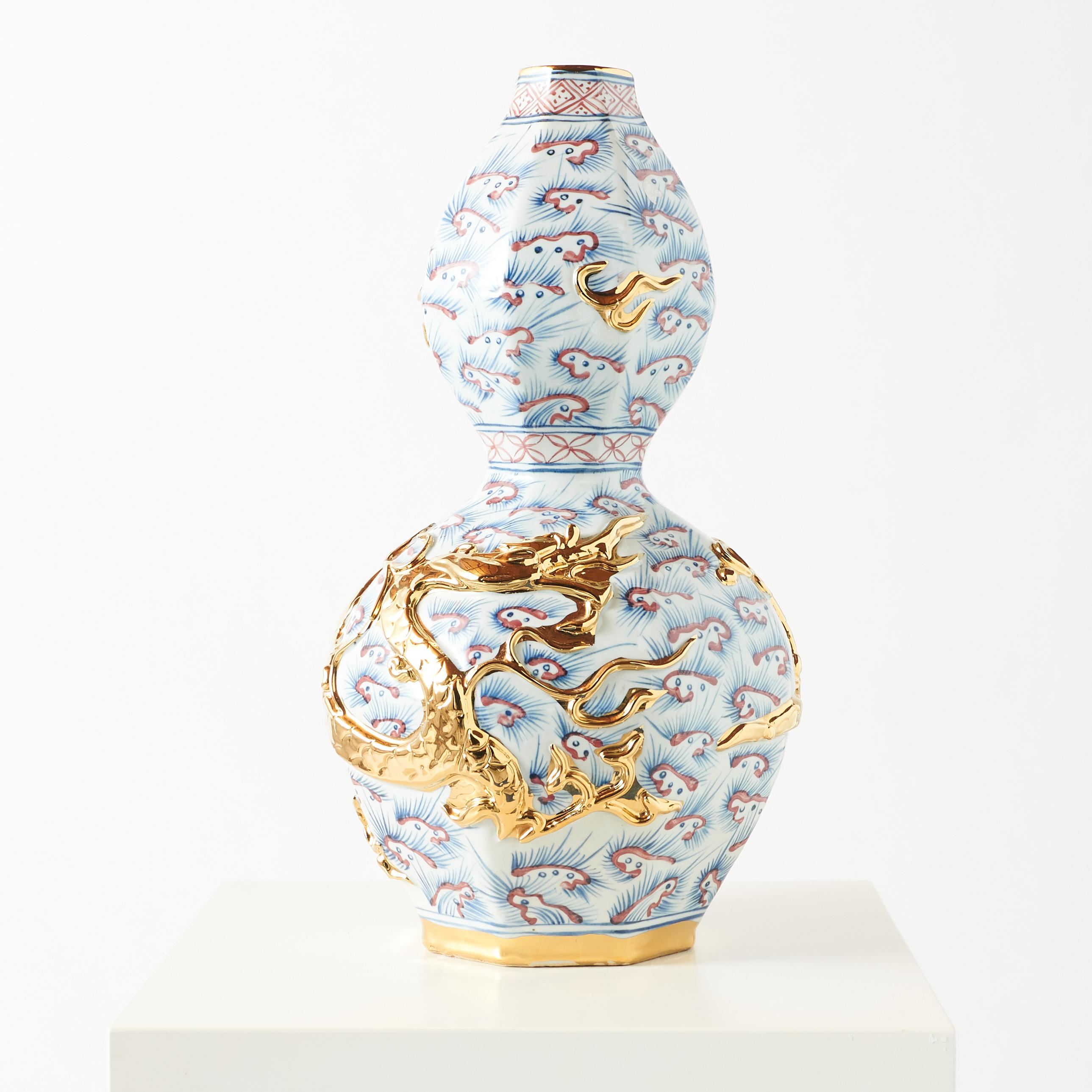 Vaso a doppia zucca in porcellana con drago dorato

Questo vaso cinese in porcellana è caratterizzato da un drago dorato che avvolge il bulbo inferiore, simbolo di potere e fortuna. È decorato con nuvole stilizzate blu e rosse, che rappresentano il