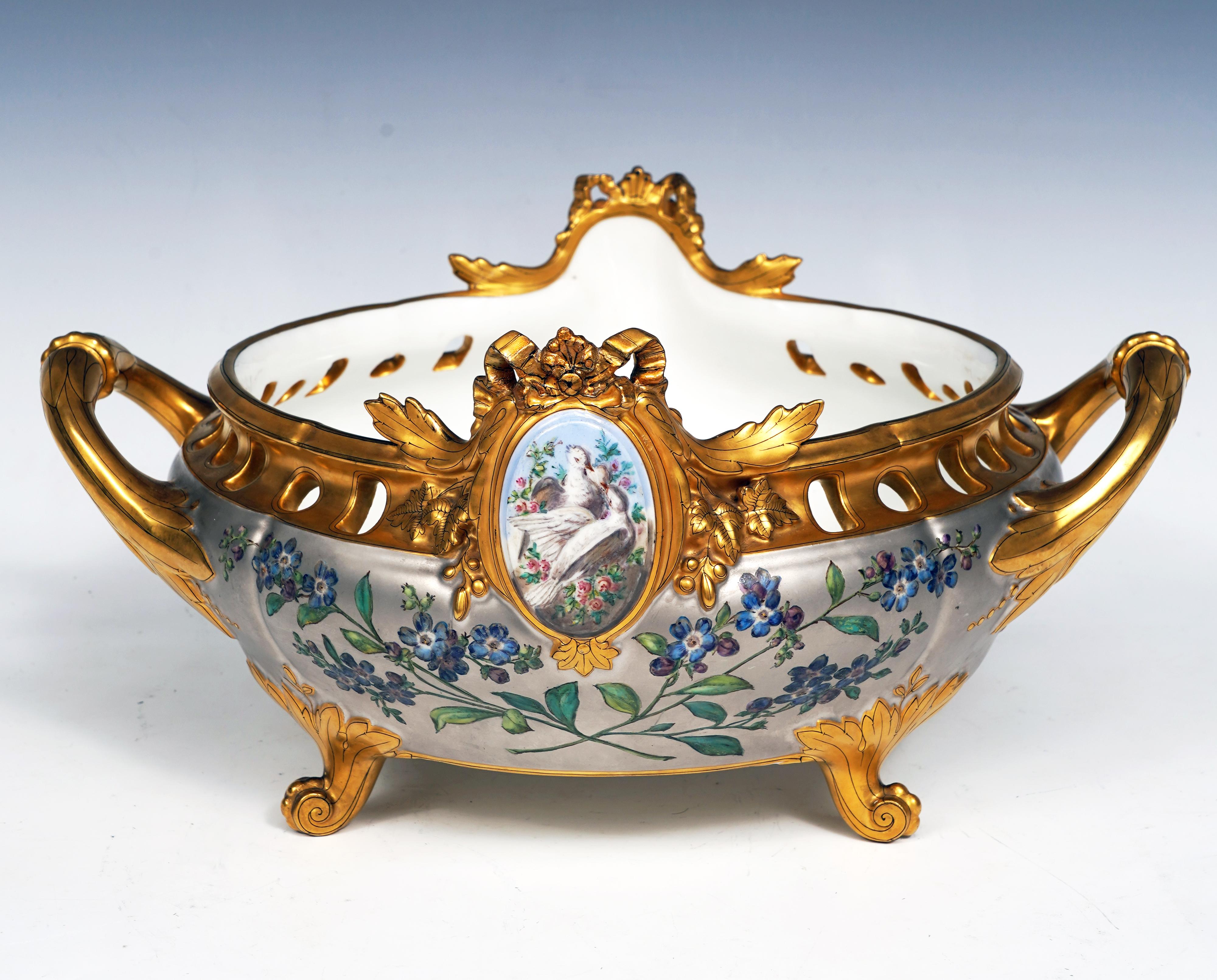 Inscrit HA et Cie et numéroté 403
Signé en rouge Escalier de Cristal Paris

Belle jardinière en porcelaine dorée et peinte. La panse arrondie à fond platine est décorée de myosotis, surmontée d'une bordure ajourée centrée de chaque côté d'un
