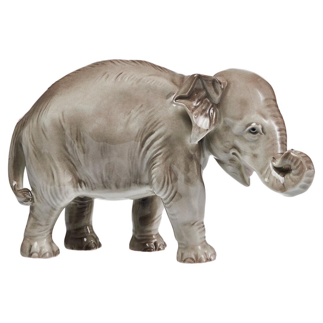 Figura de elefante de porcelana con tronco hacia arriba pintada bajo vidriado en venta