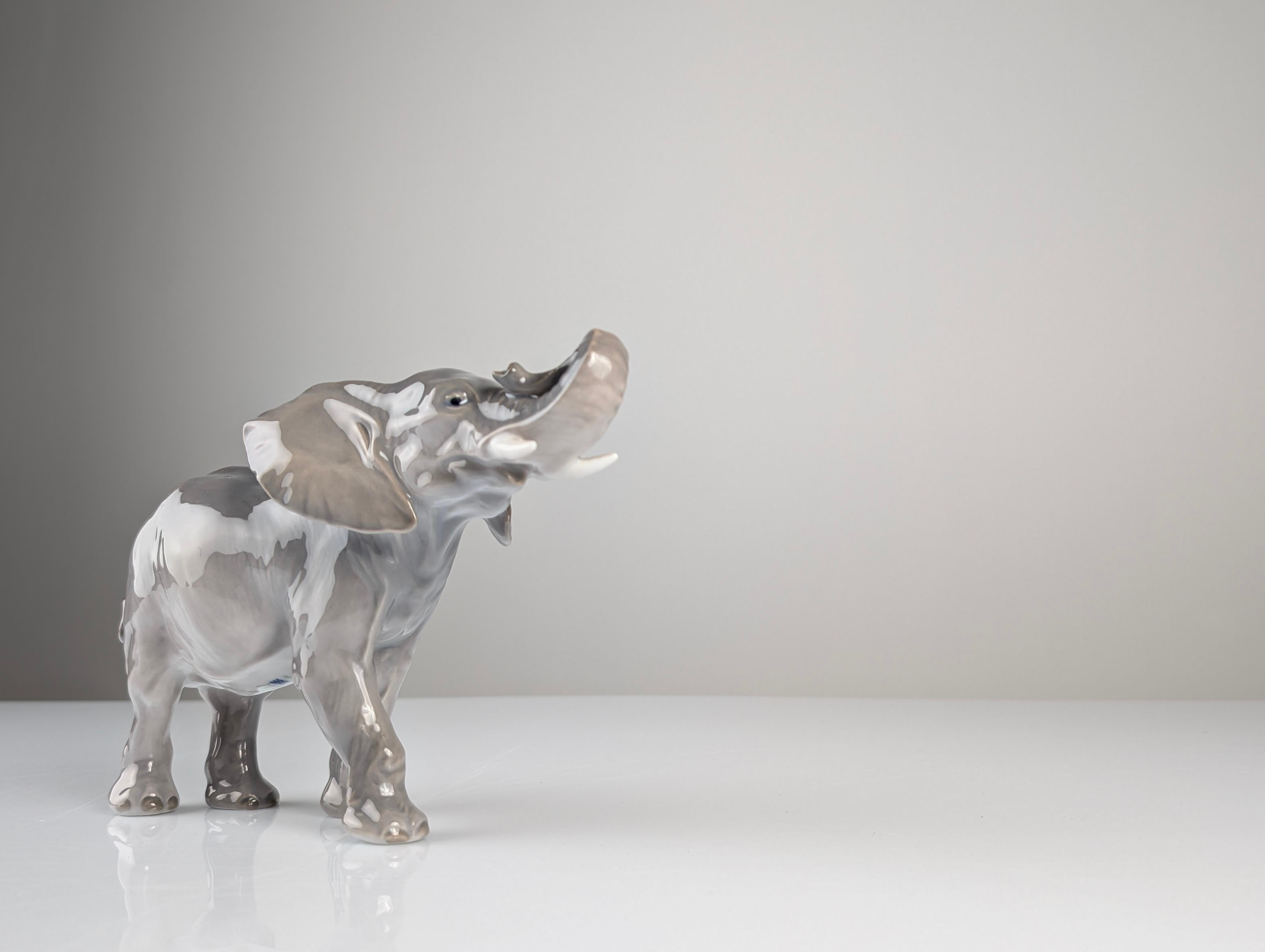 Exquisite porcelain piece designed by renowned sculptor Peter Herold in 1915, during his collaboration with the prestigious Royal Copenhagen factory between 1908 and 1919. This elephant, model number 1771, captures the majesty and strength of the