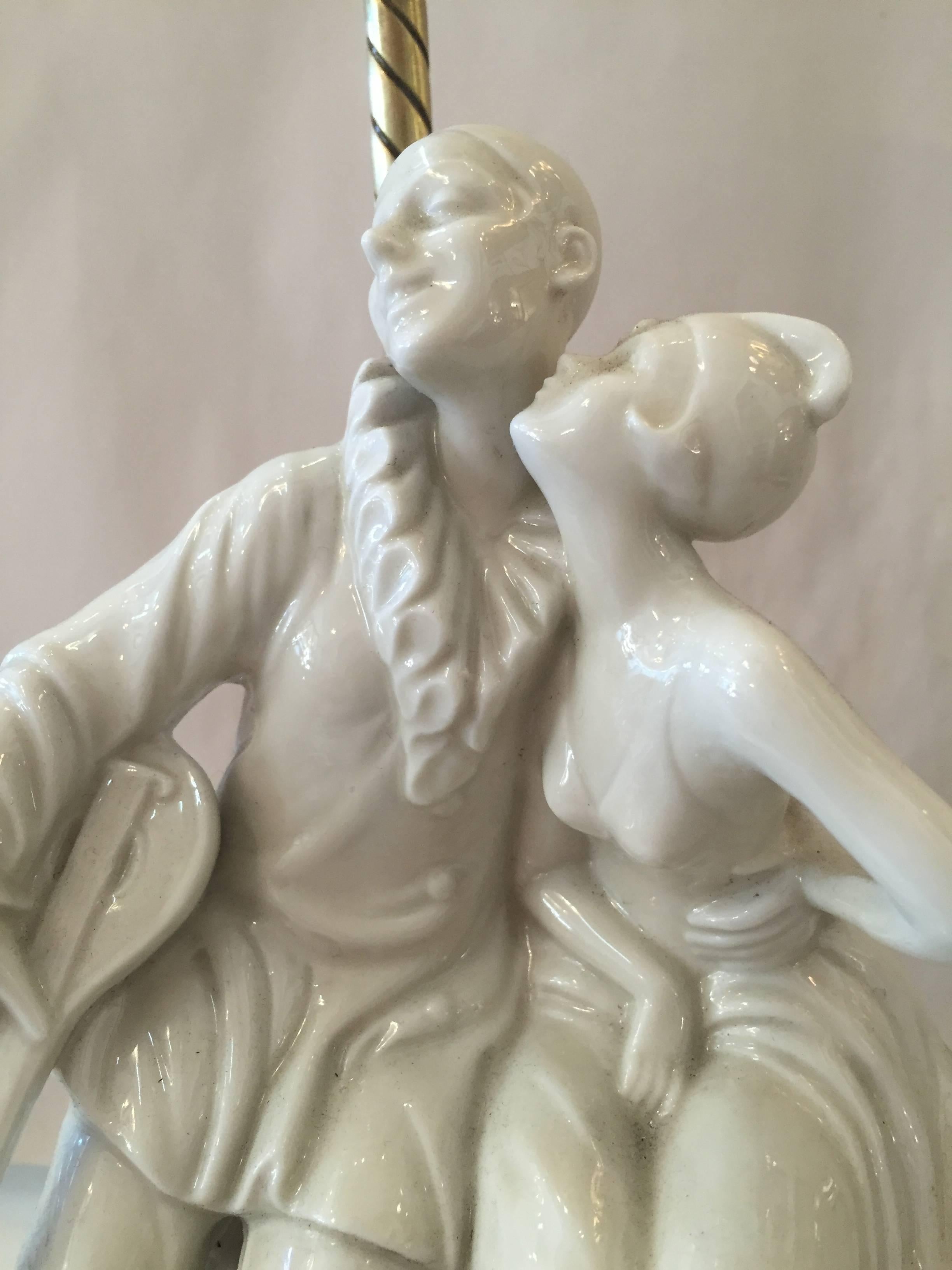 Art Deco era porcelain and brass figurine lamp of a Harlequin girl kissing her minstrel clown.

Measure: Base 7