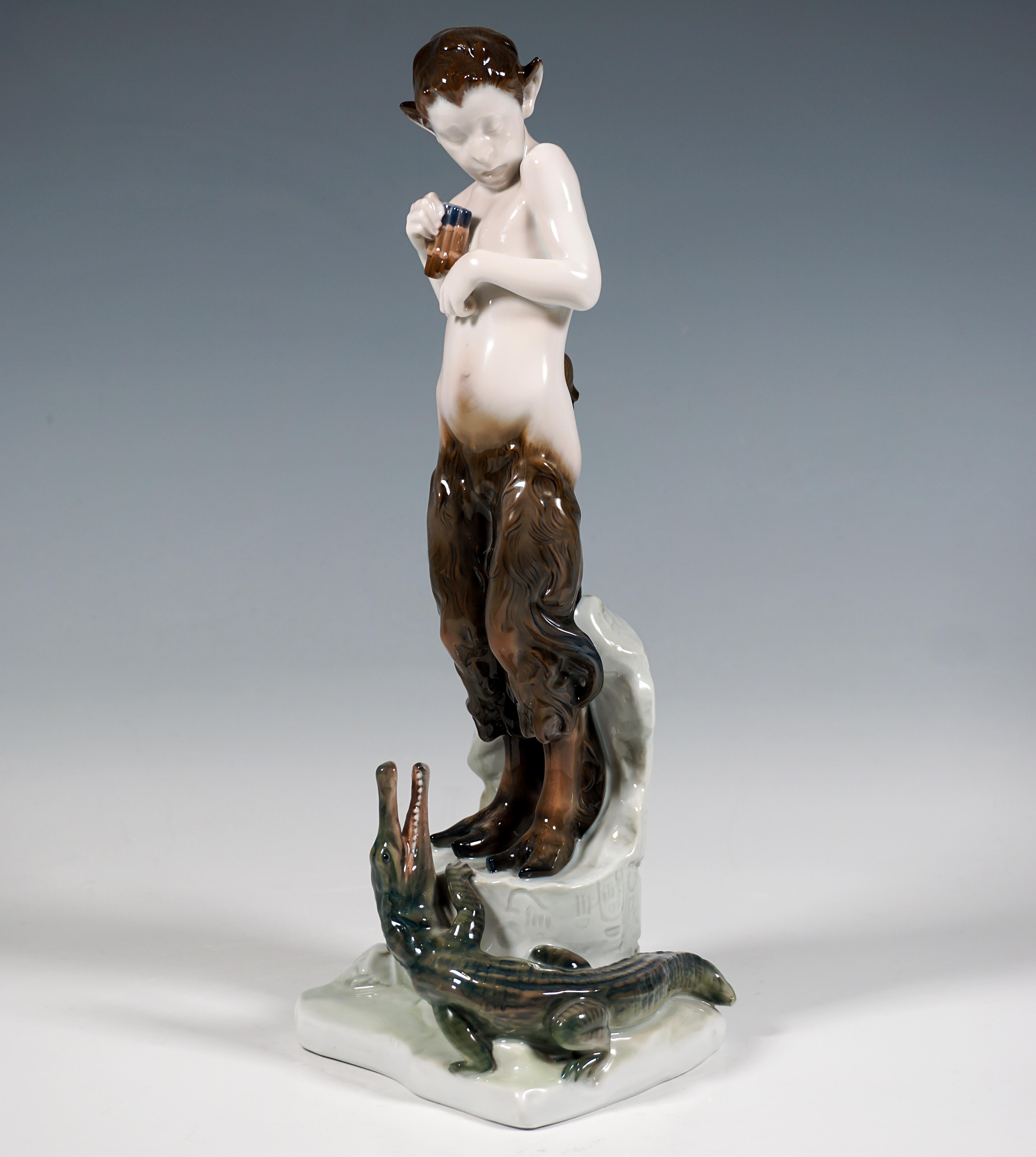 Admirable Art Nouveau Figurine by Rosenthal:
Frightened faun standing on a broken piece of ruins with Egyptian inscriptions, holding a pan flute in his right hand, at his feet a crocodile with its mouth open looking up and climbing towards him.
On a