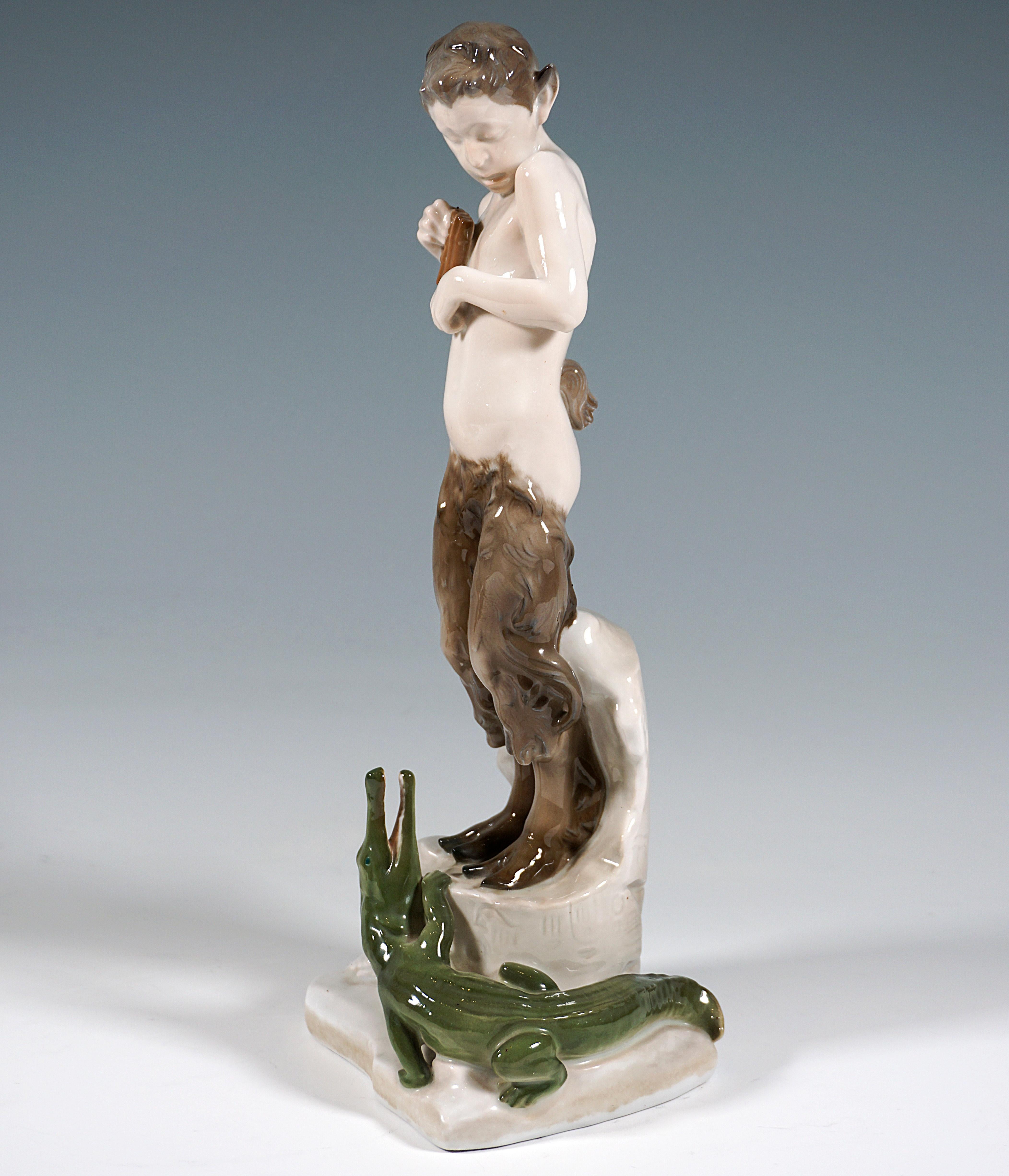 Admirable Art Nouveau Figurine by Rosenthal.
Faun terrified standing on a broken piece of ruins with Egyptian inscriptions, holding a pan flute in his right hand, at his feet a crocodile, looking up at him with open mouth and climbing up to him.
On
