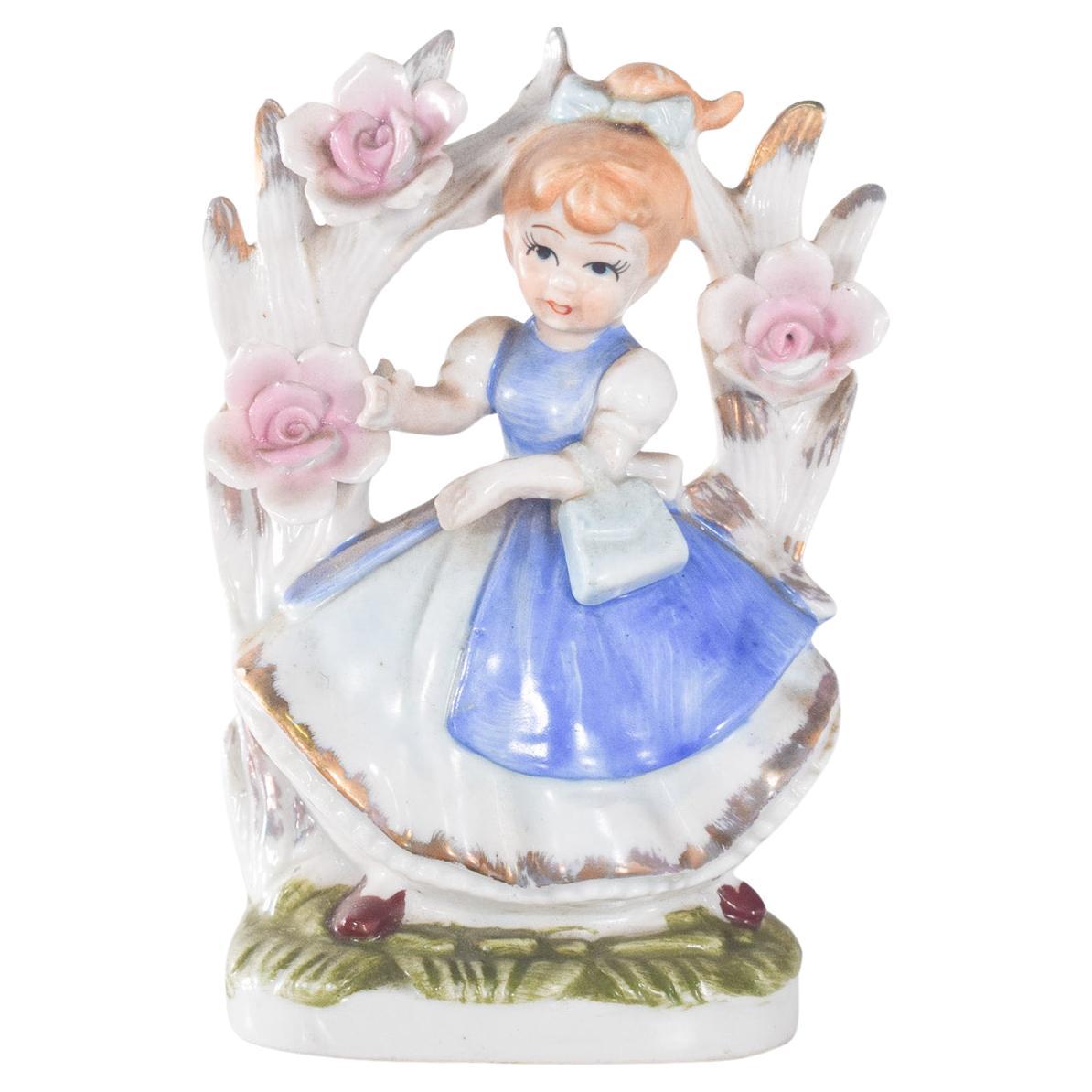Figura de porcelana de niña sentada