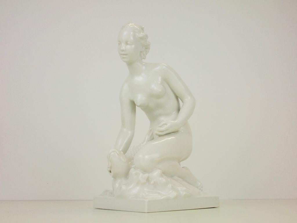 Stunning vintage midcentury German porcelain statuette by Suze Muller depicting a kneeling nude young female holding a koi fish.
This very fine white porcelain figurine has been manufactured by the Konigliche Porzellanmanufaktur Berlin and is in