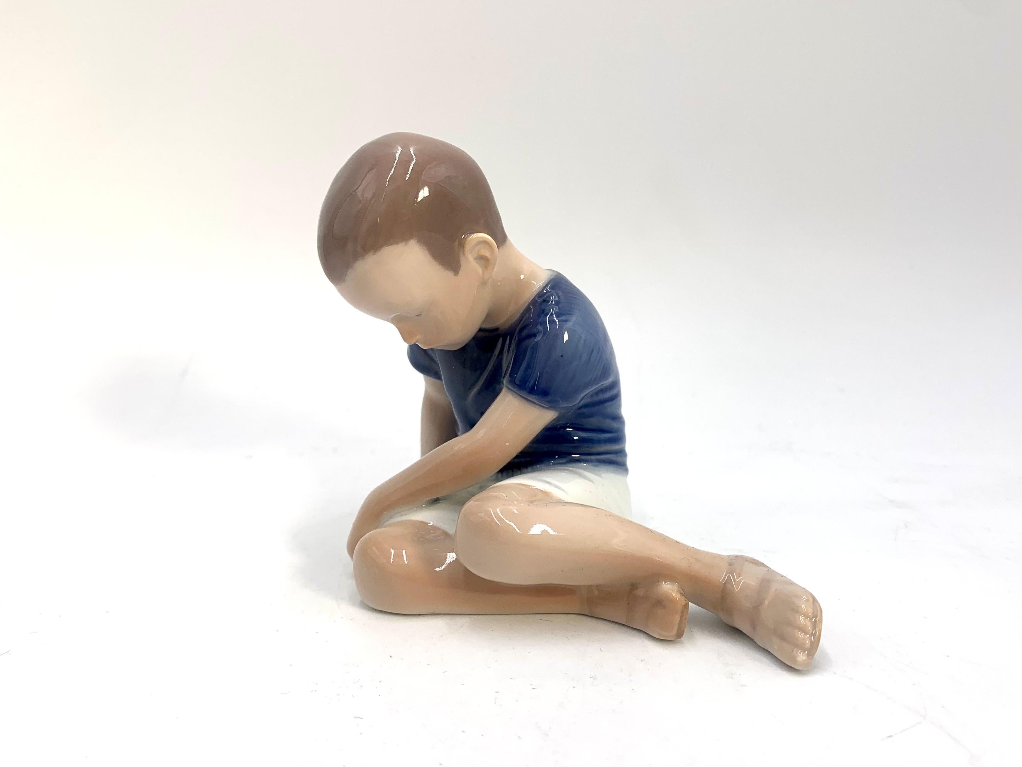 Porcelain figurine of a boy

Made in Denmark by Bing & Grondahl

Manufactured in the 1980s.

Model number # 1671

Very good condition, no damage

Measures: height 10cm, width 12cm, depth 7cm.