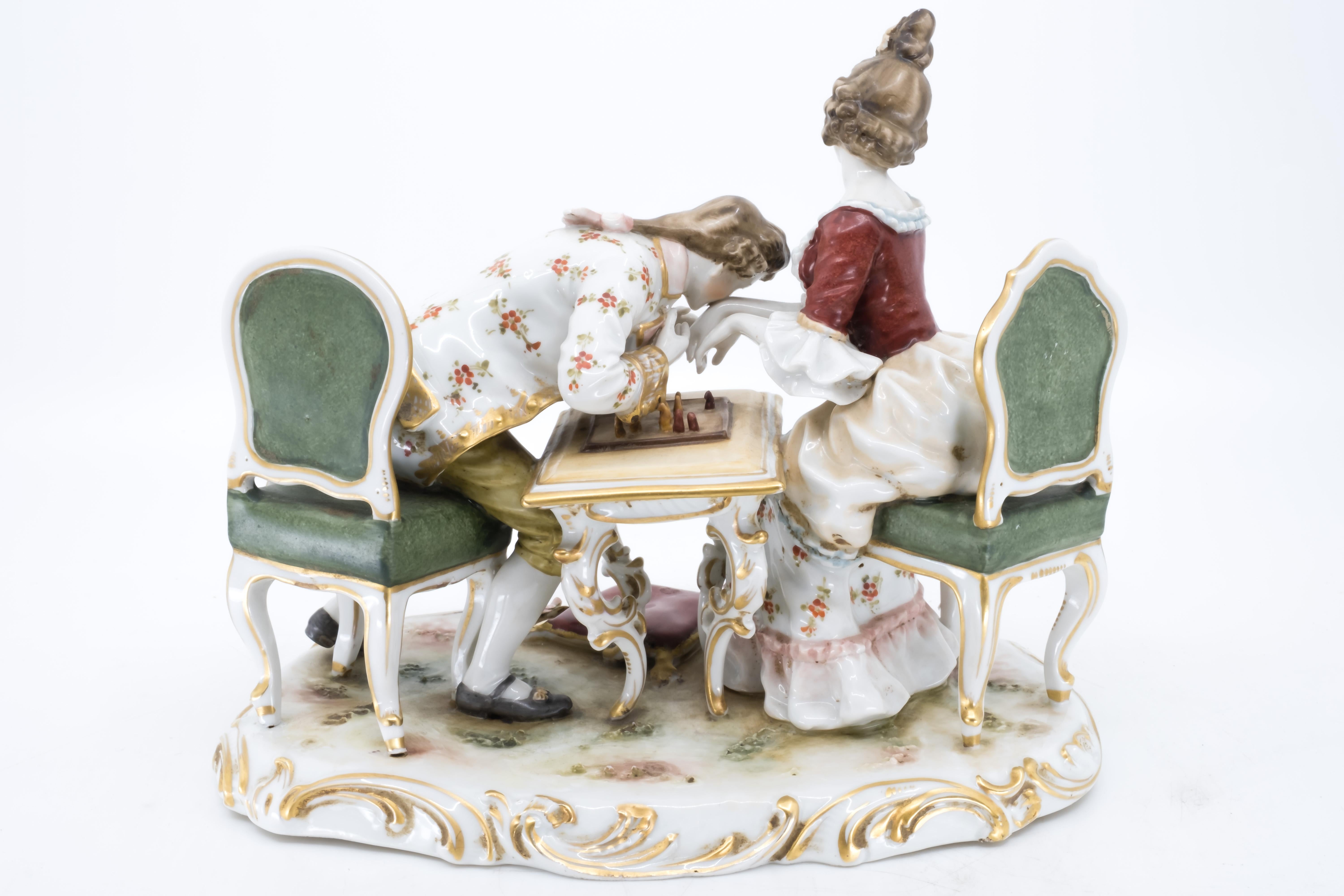 Allemand Figurine en porcelaine d'un couple jouant aux échecs, Allemagne, peinte à la main en vente