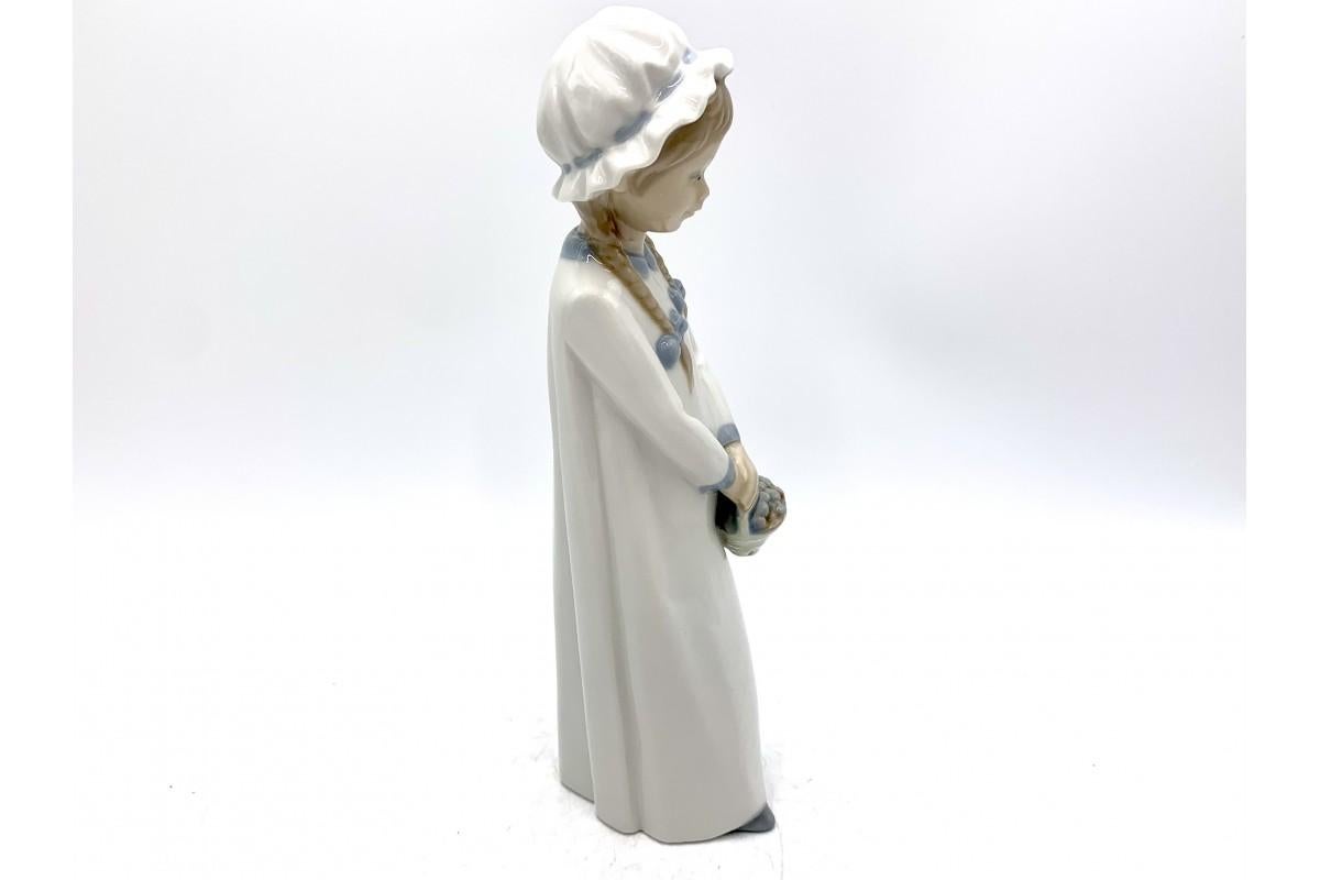 Porcelain figurine of a girl with braids holding a basket.

Signed Zaphir from the name of the porcelain collection from the Lladro brothers' Porcelain Factory.

Made in Spain in the 1970s

height 26cm, width 6cm, depth 9cm

height 24cm,