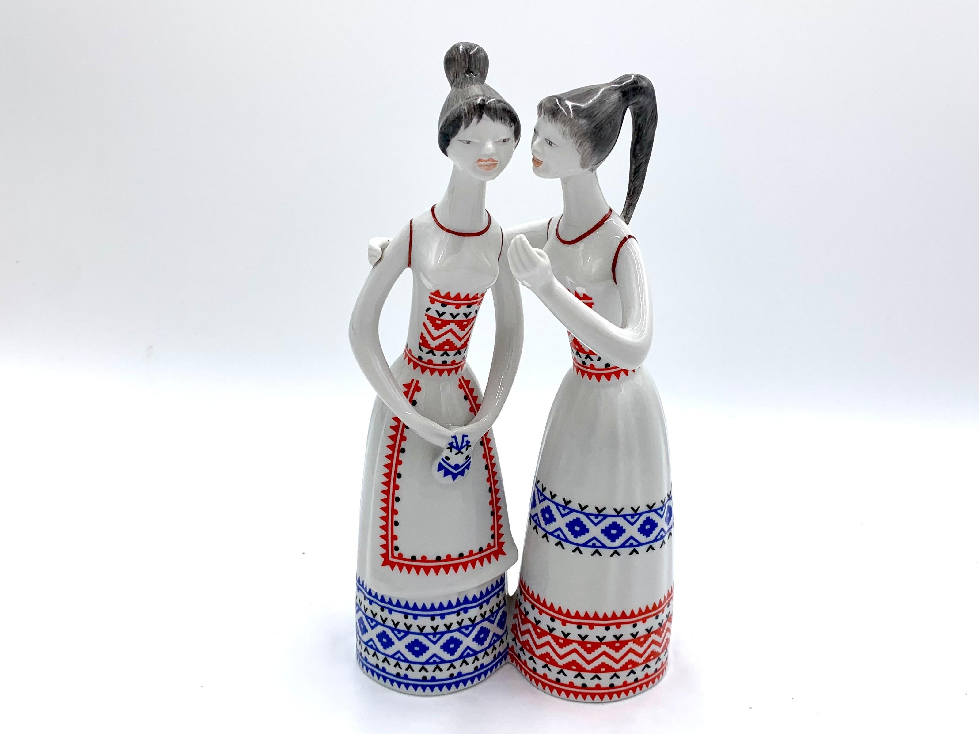 A tall porcelain figurine depicting gossiping women in folk dresses with embroidery. Signed Hollohaza. Designed in the 1960s by Marta J Seregely.

High-quality porcelain. Height 23 cm. Very good condition.