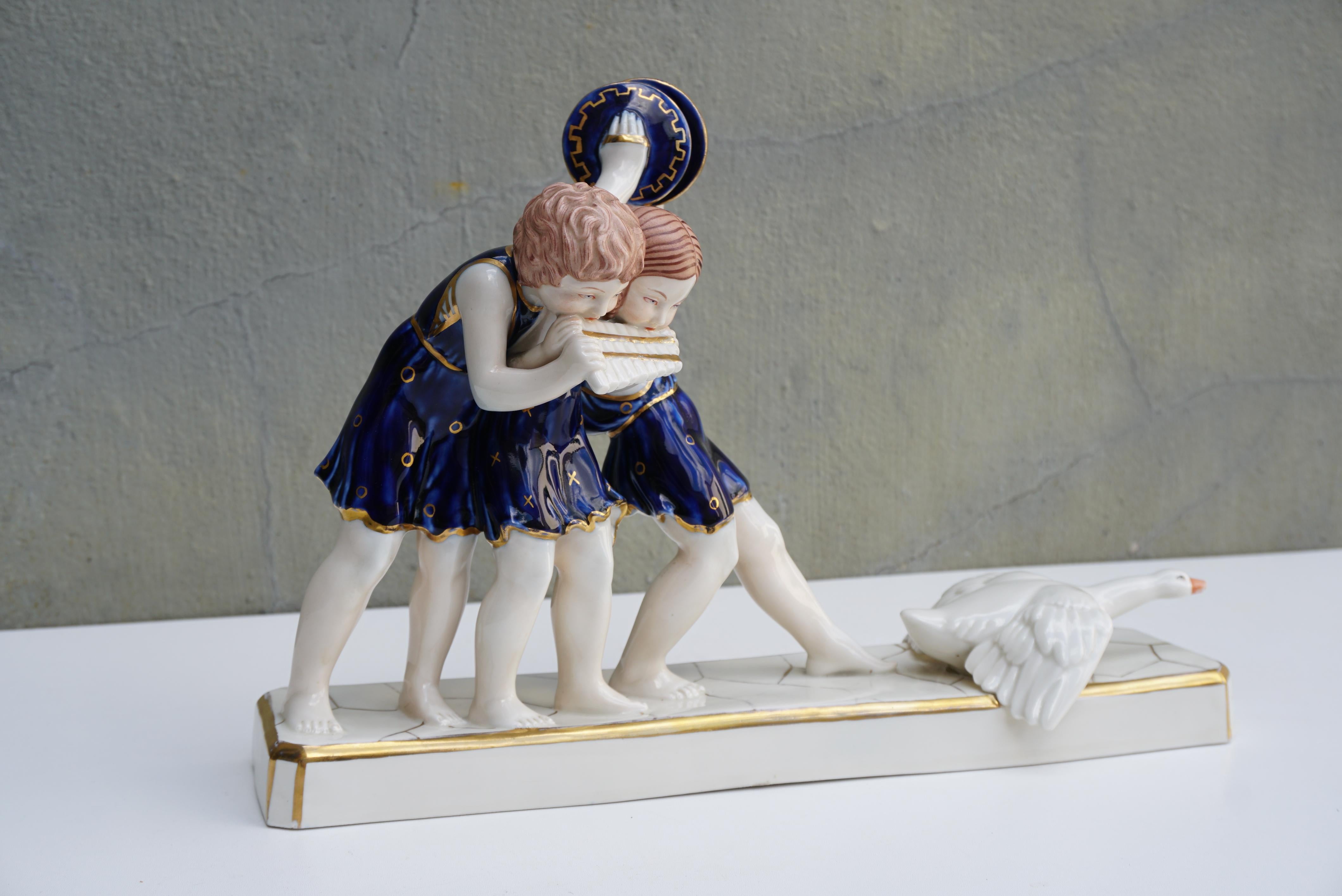 Art Deco Royal Dux hand painted porcelain figurine. Czech Republic, 1940s.

Three children making music.
Czech Royal Dux polychrome enameled porcelain, cobalt blue costume, gold accents, brand and pastille under the base.

Height 10.2